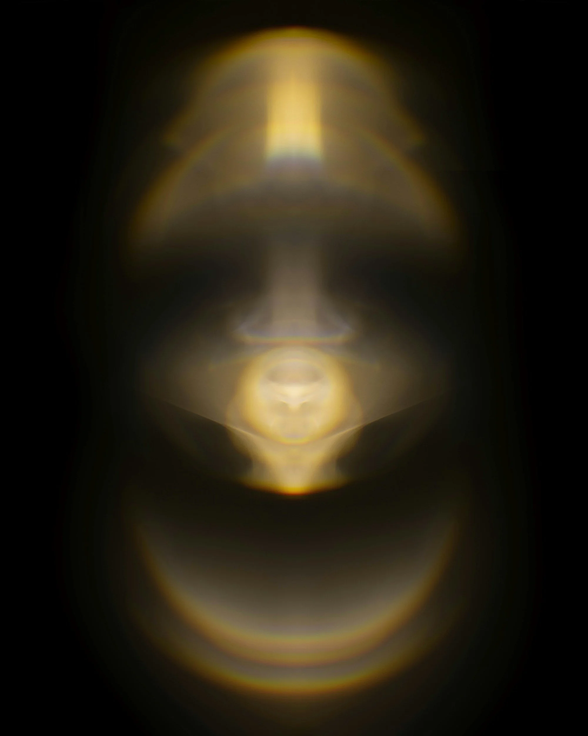Close-up of a golden light refraction with a blurred, dark background.