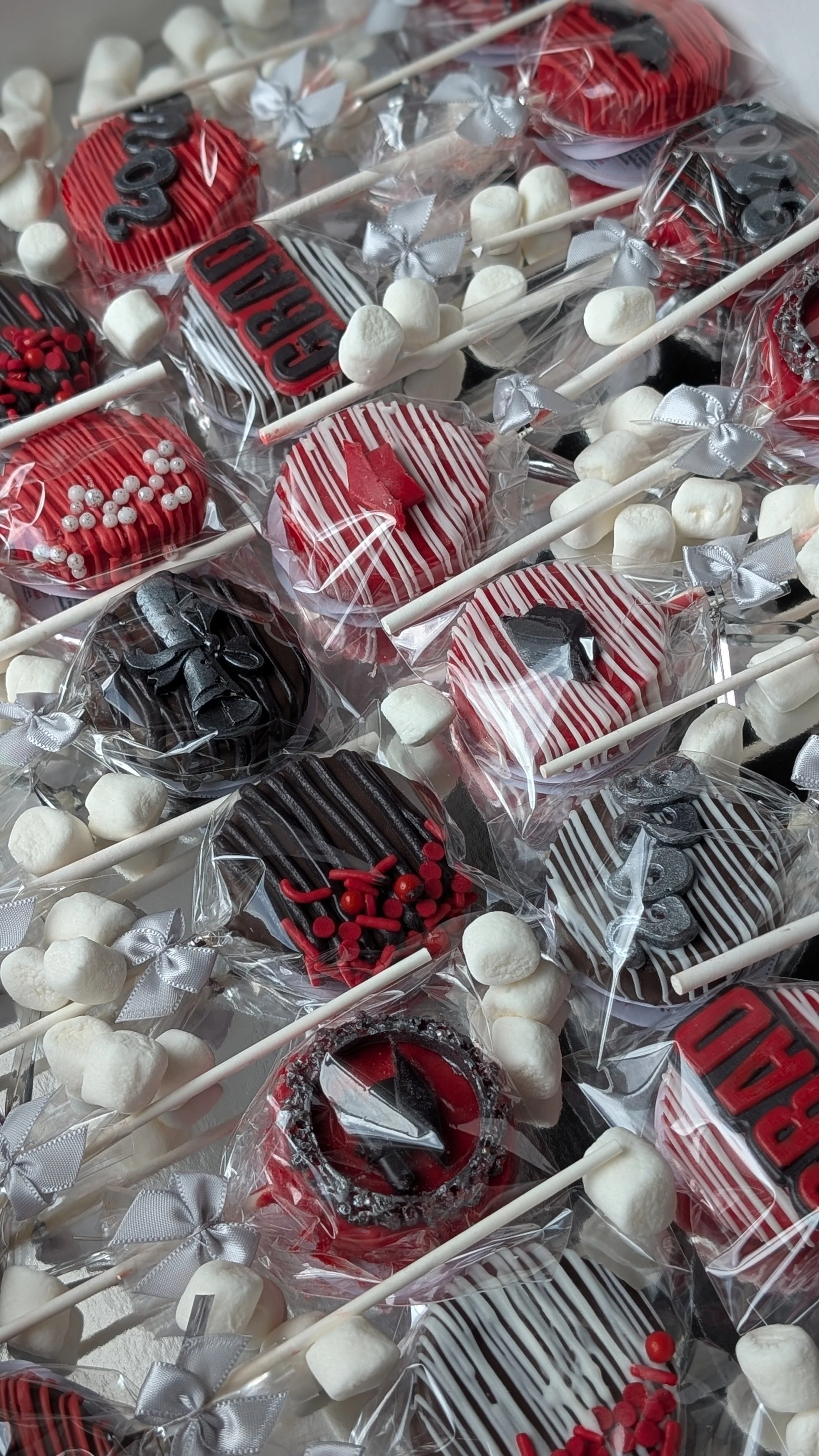Assorted decorated cake pops on sticks with holiday-themed designs and packaging.