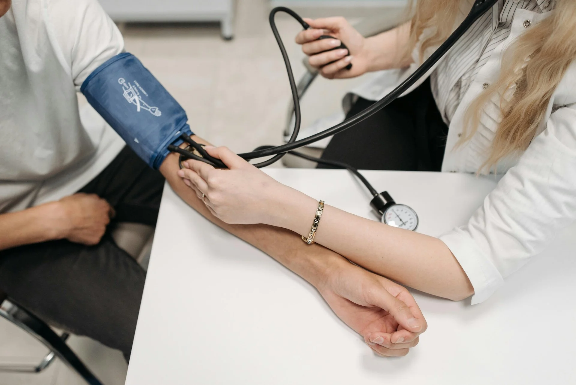 A doctor using a sphygmomanometer to measure a patient's blood pressure during a medical exam