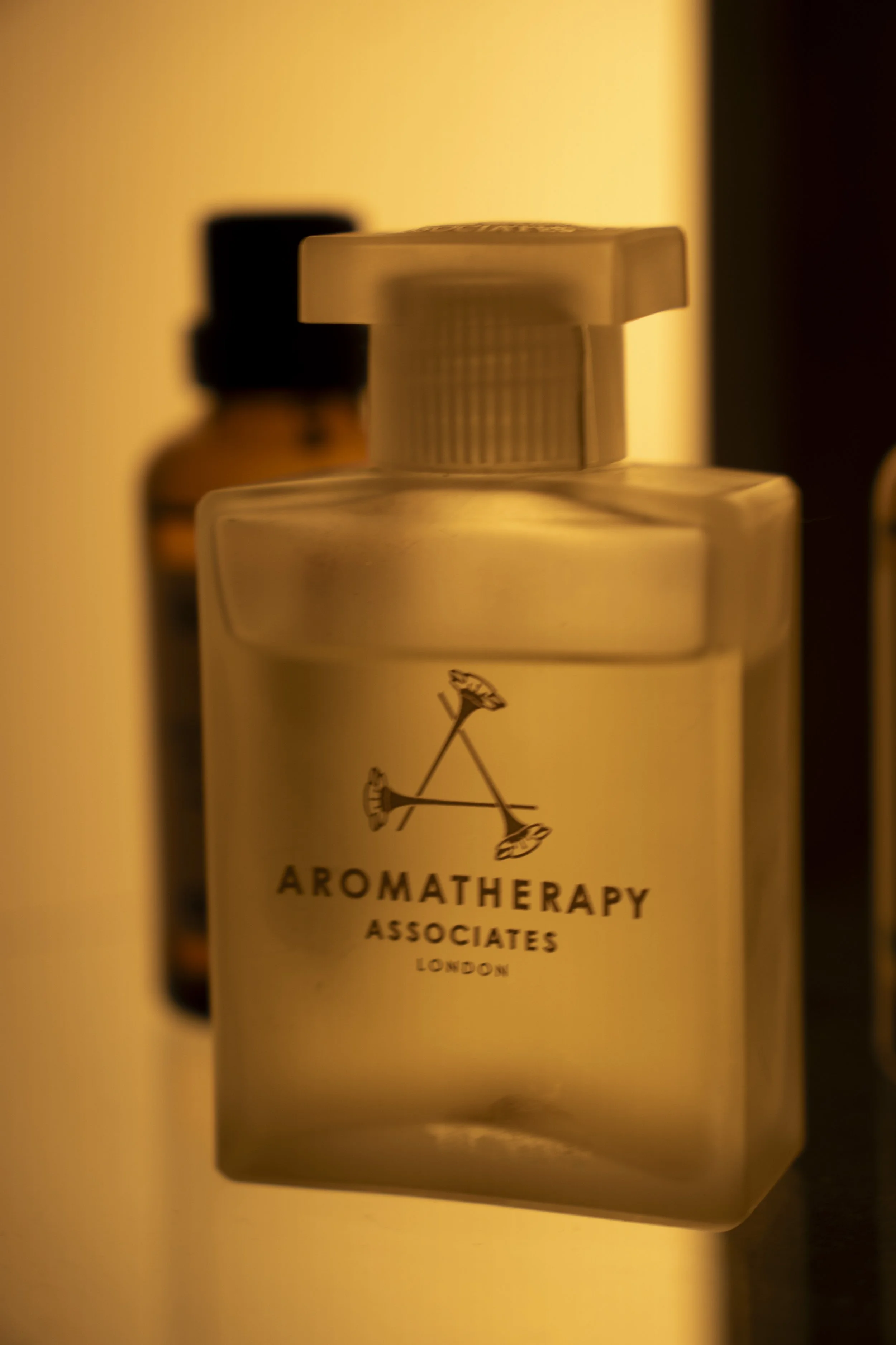 Bottle of aromatherapy associated with London, featuring a white label with black text and a small graphic of a flower.