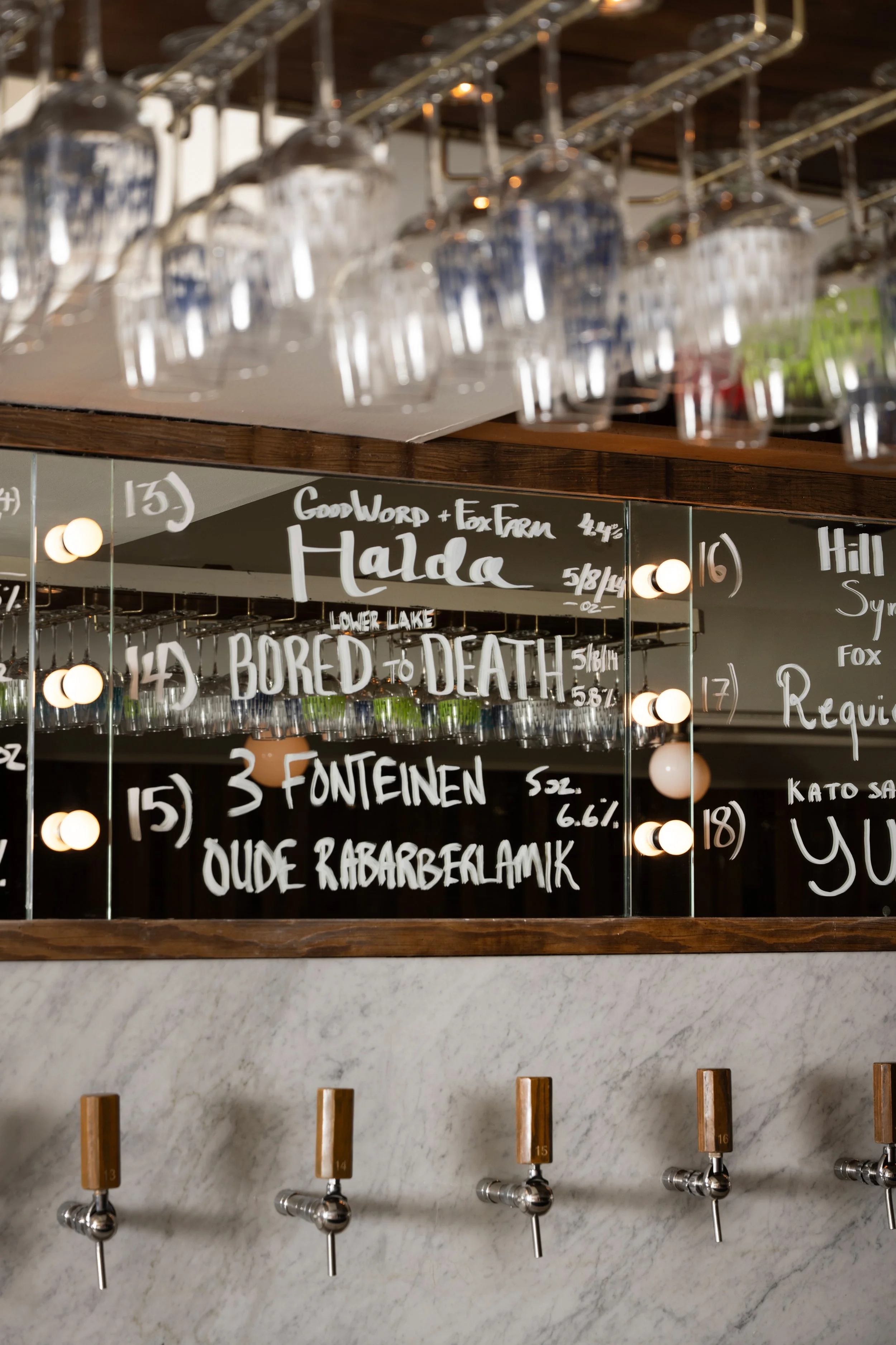 Close-up of Tørst's handwritten tap list on mirrored bar back, featuring beers from 3 Fonteinen, Fox Farm, and GoodWord