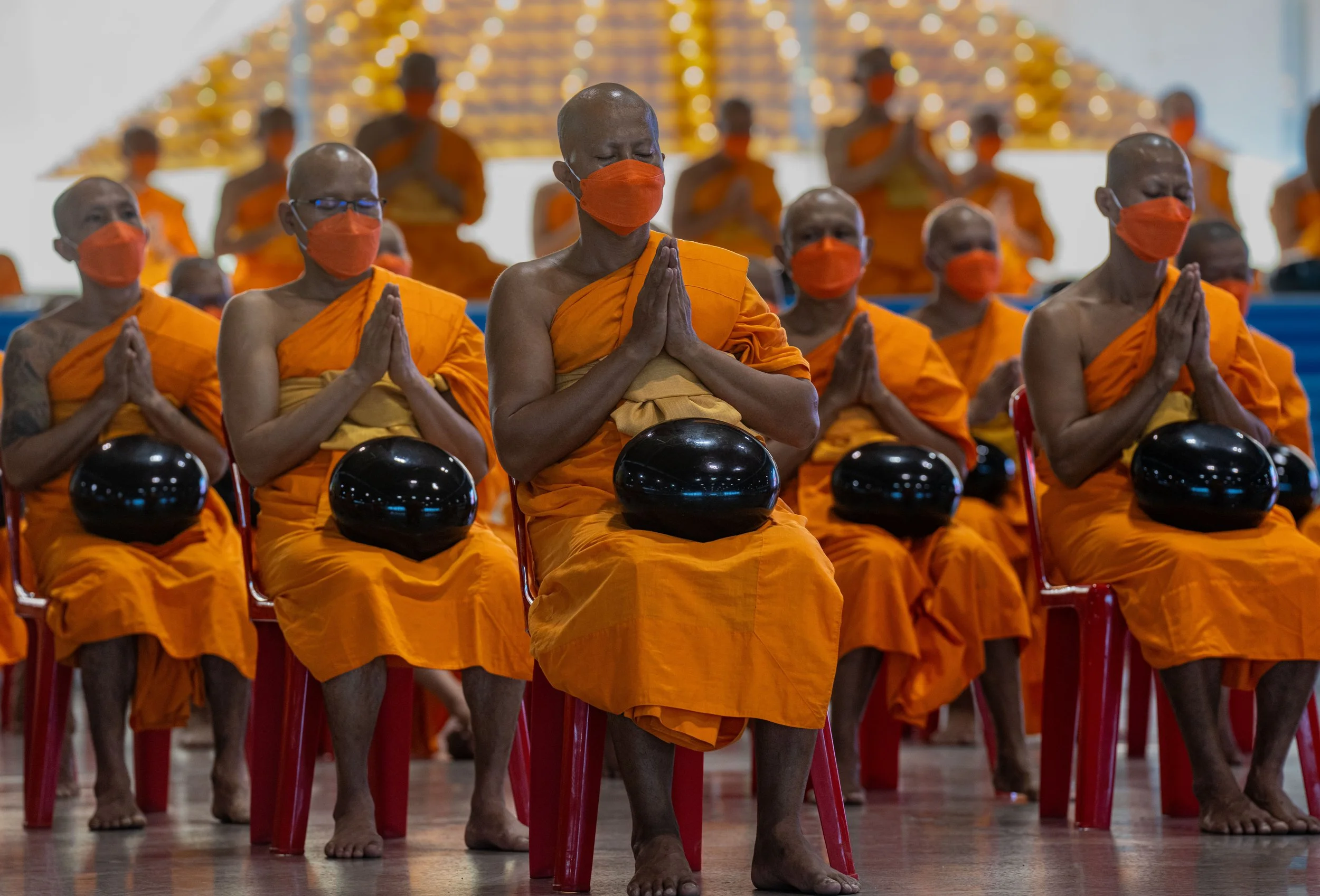 Monks pray with alms bowls at Magha Puja day in Thailand