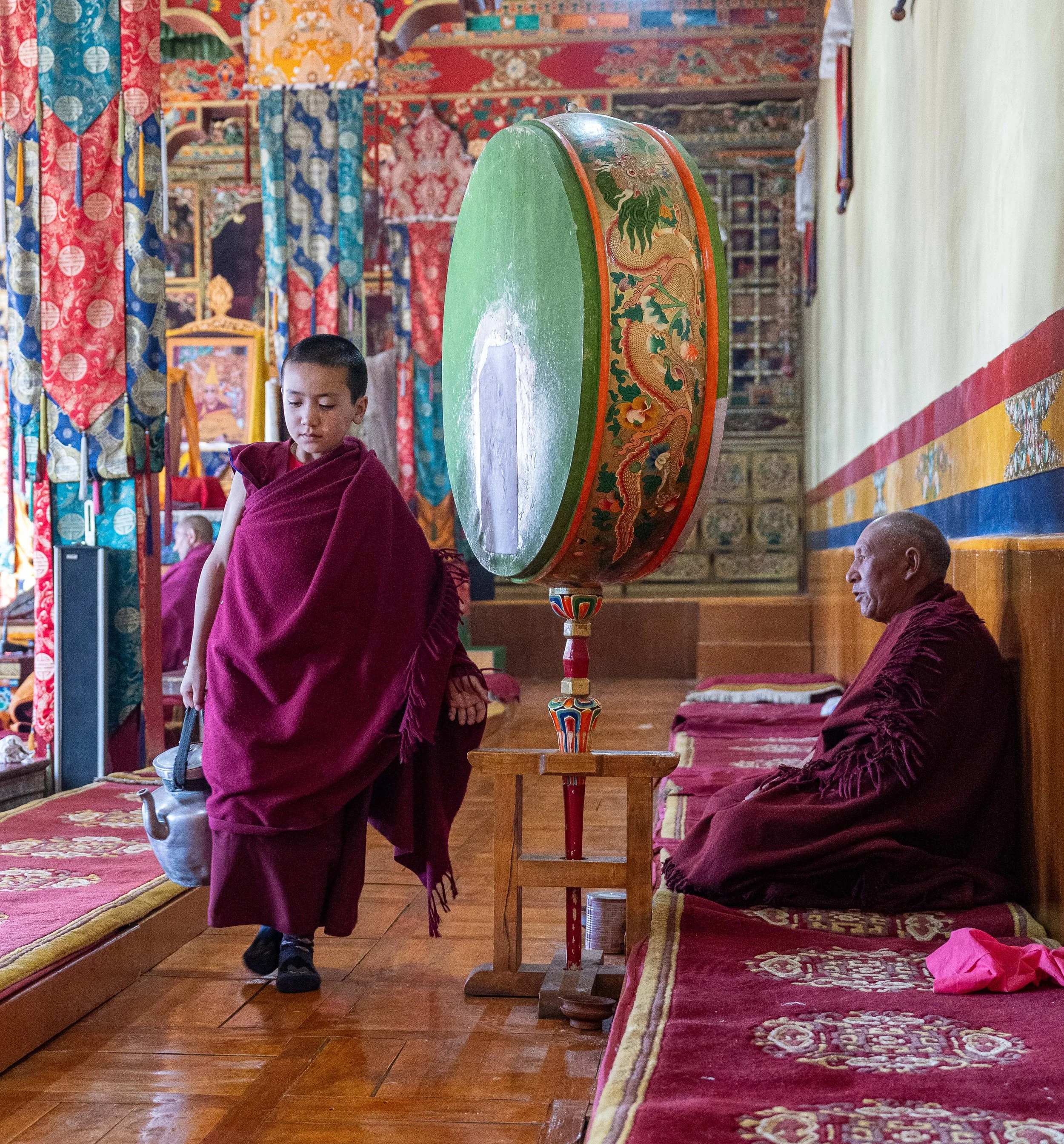 A young monk carries a pot of Tea at a the Thisky Monastery in India