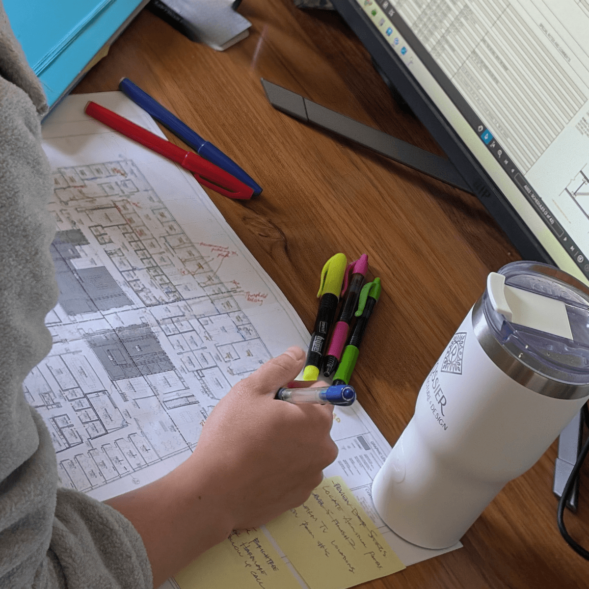 Construction drawings being checked and marked up for quality control on a wooden desk