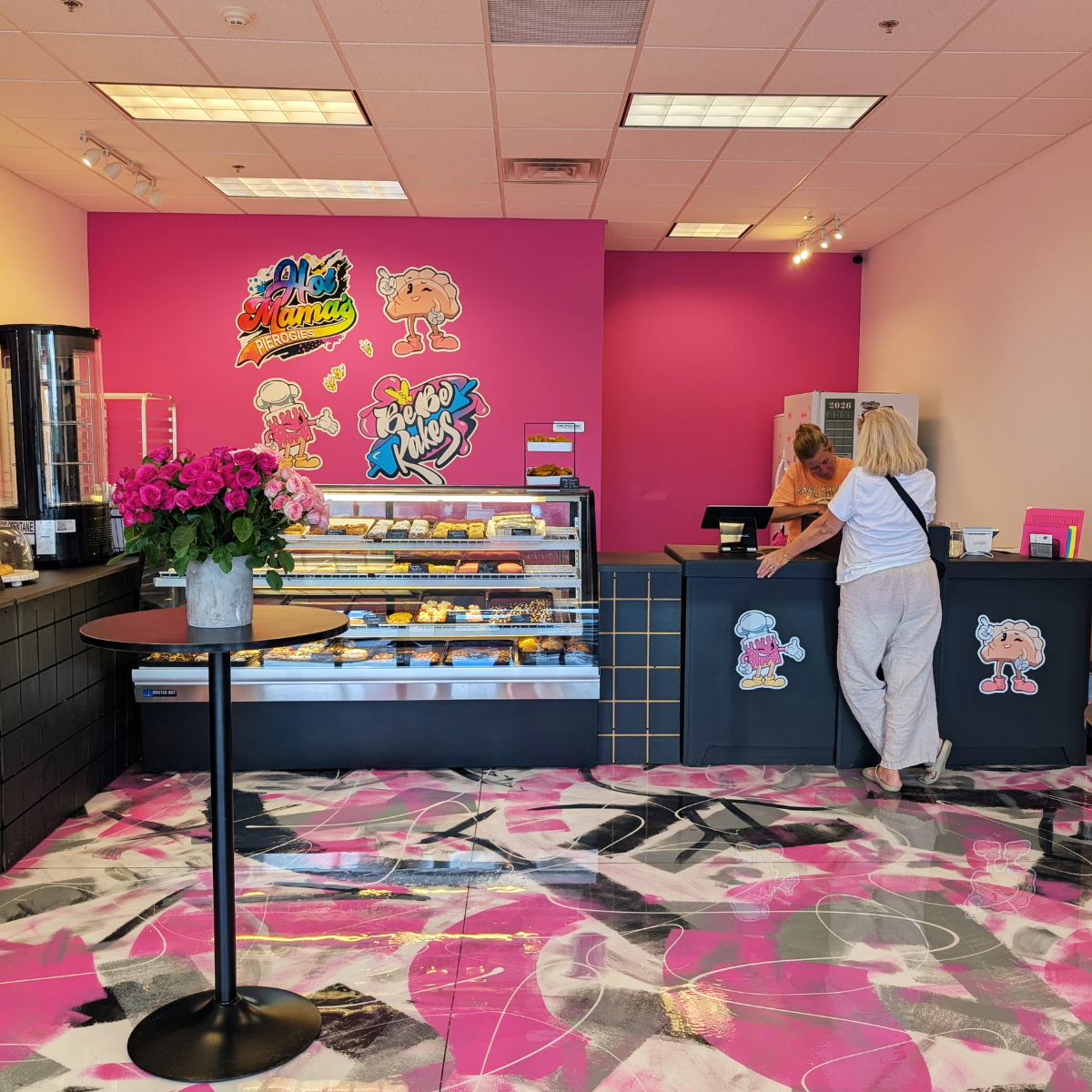Bakery and Perogies Shop with pink wall, pastry display, and black counters