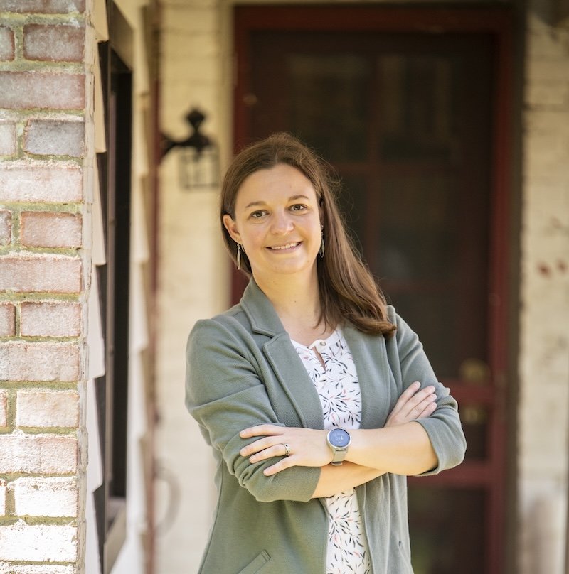Headshot of Katelyn standing outside with her arms crossed.