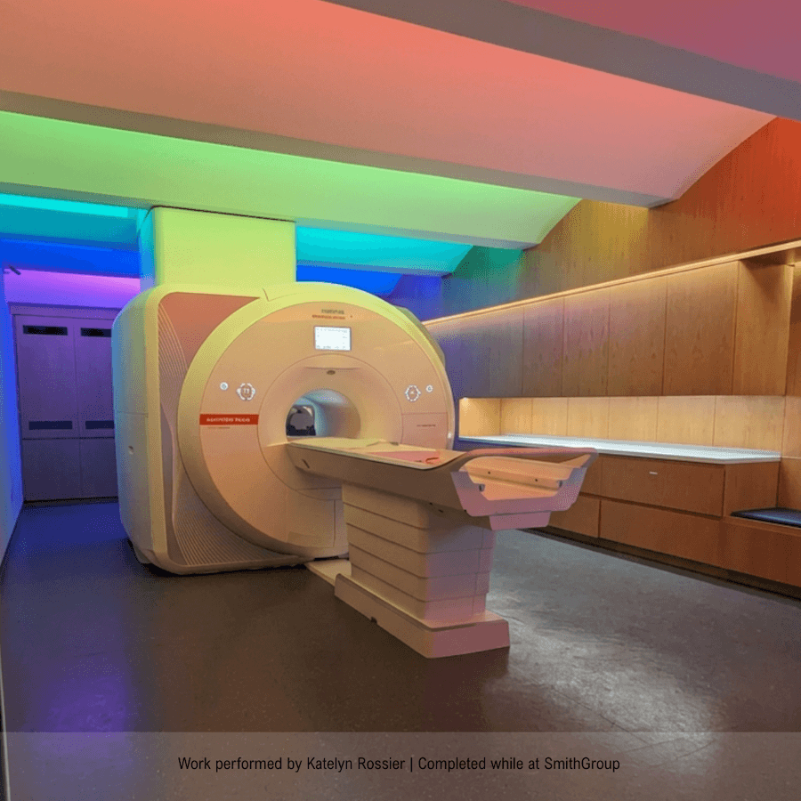 A modern MRI machine in a medical facility with colorful ambient lighting in purple, red, green, and blue hues.