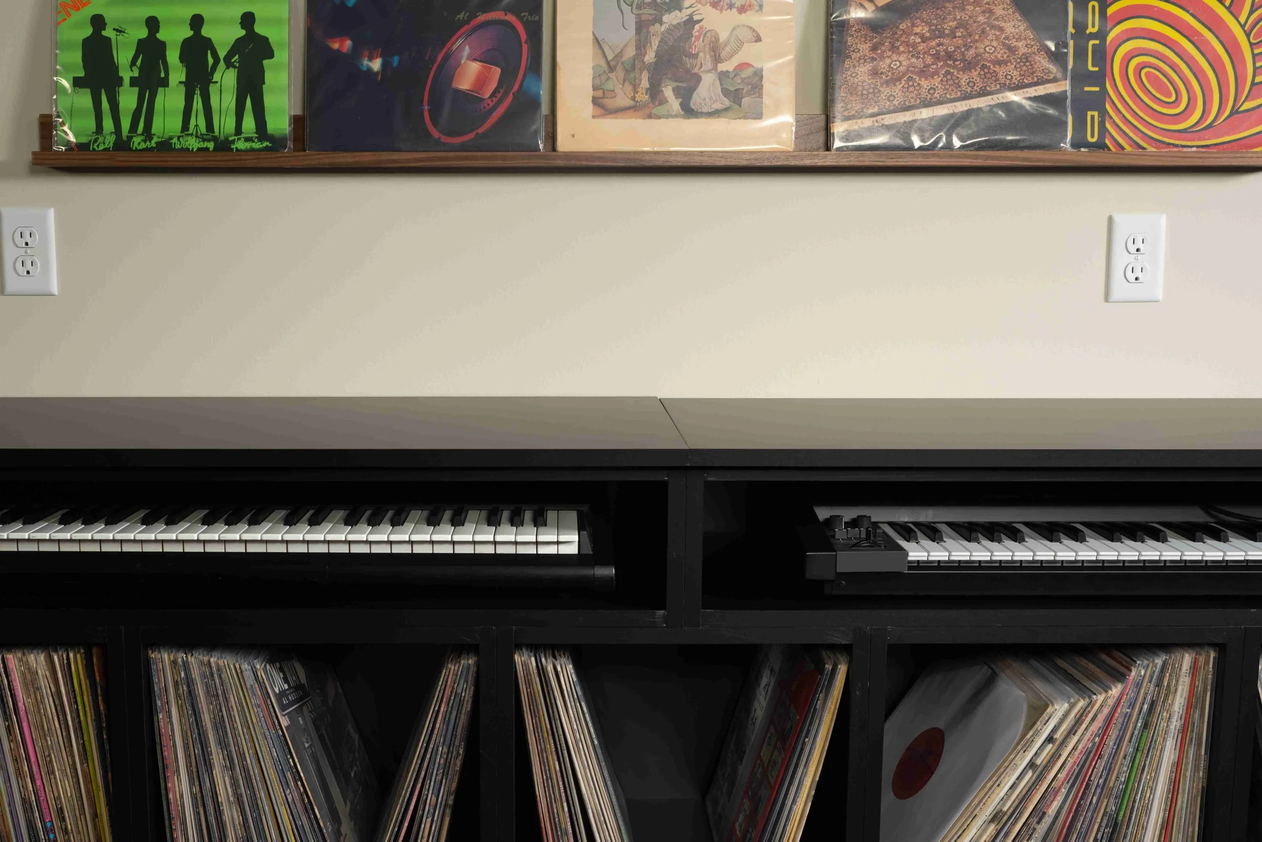 Album art display above built-in cabinetry with keyboard station, Minneapolis basement