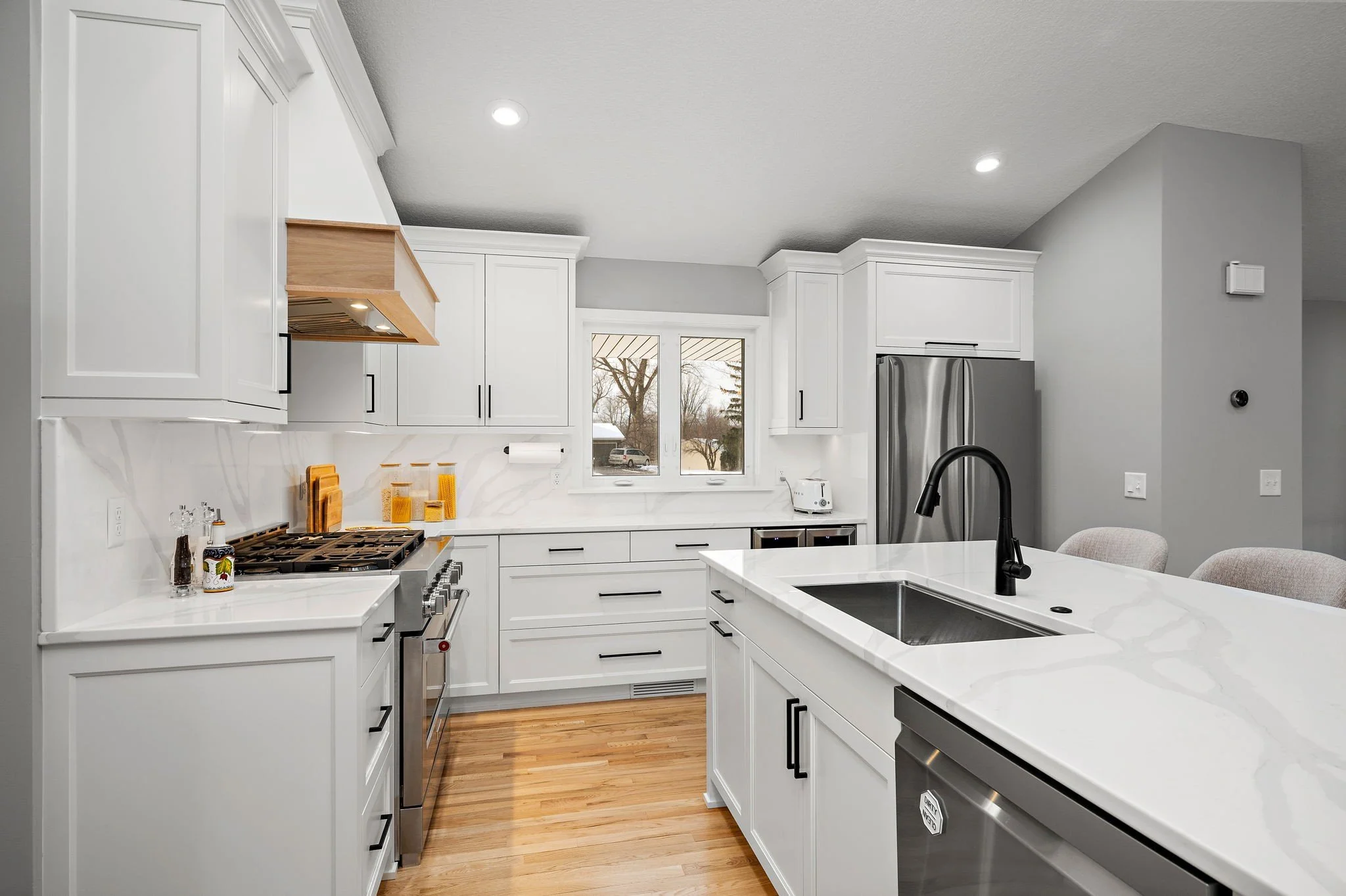 White shaker kitchen cabinetry with quartz
countertops and stainless appliances,
Minnetonka