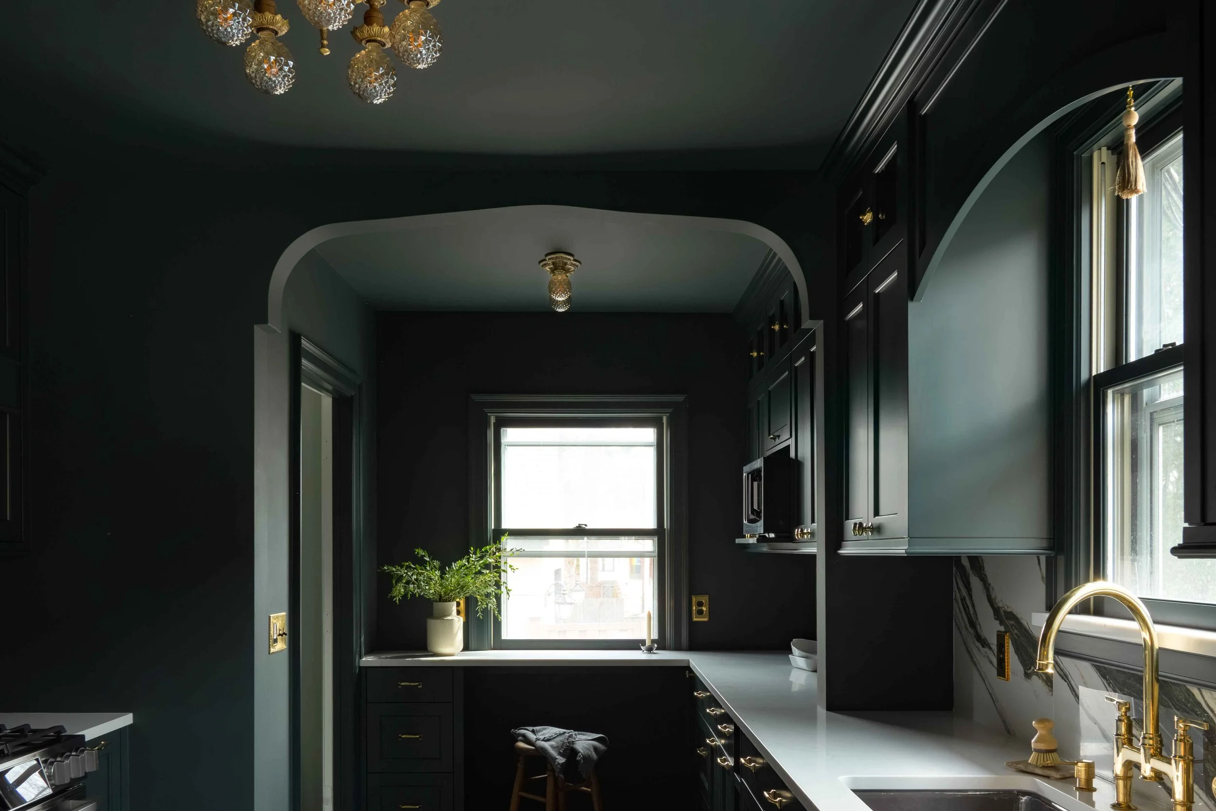 dark green custom kitchen remodel with brass chandelier and arched millwork, Minneapolis