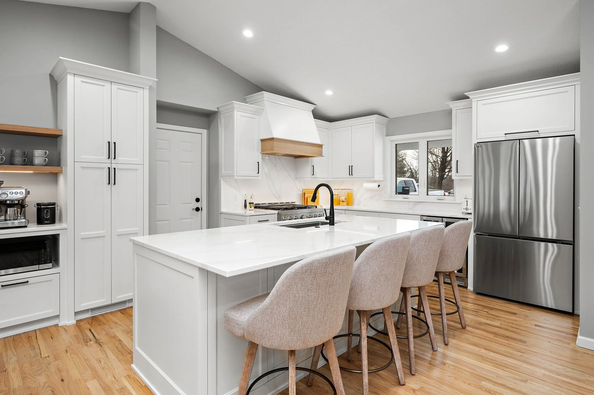 Quartz island with matte black fixtures and
barstool seating, Minnetonka kitchen remodel