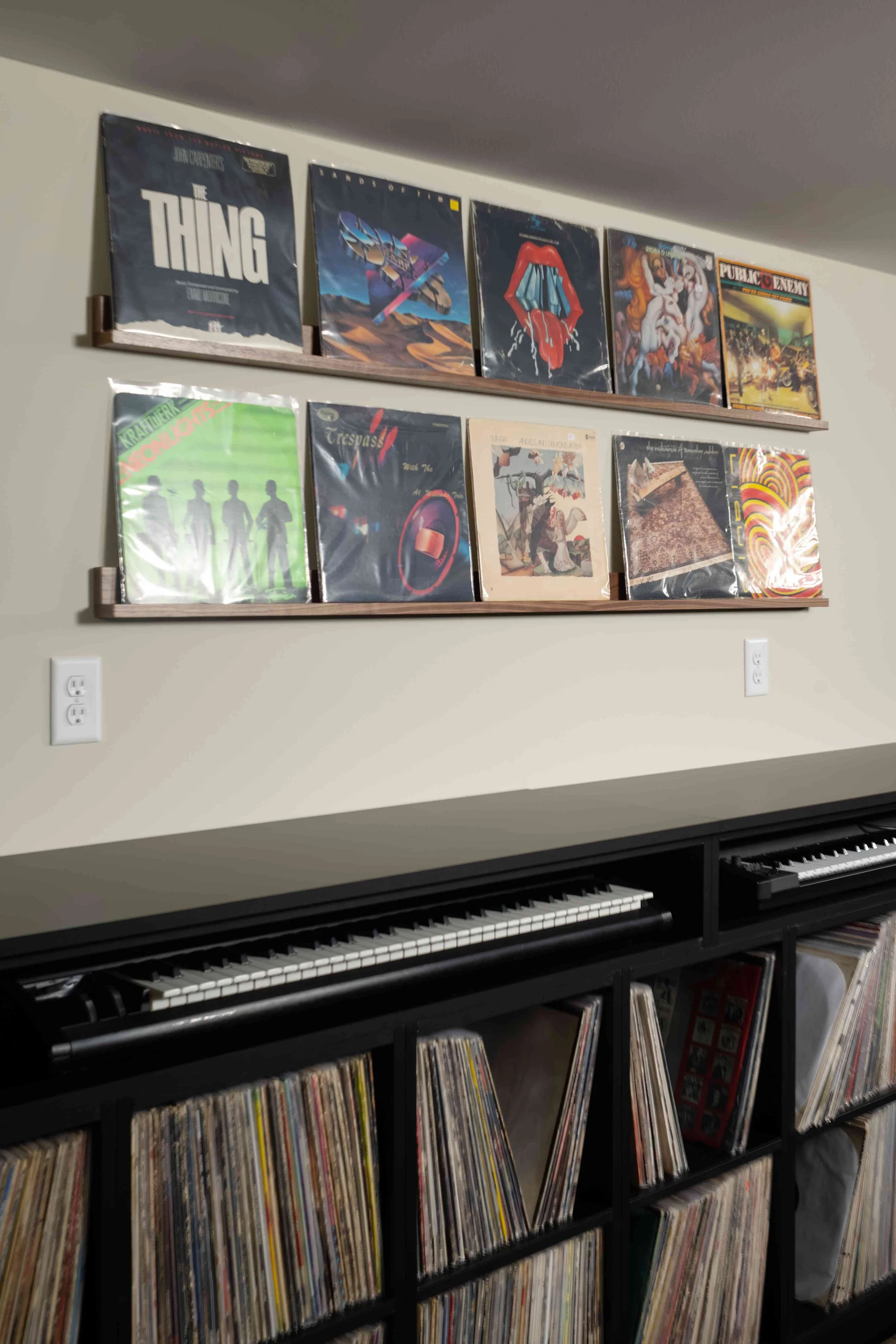 Framed album art display above built-in cabinetry, Minneapolis record room