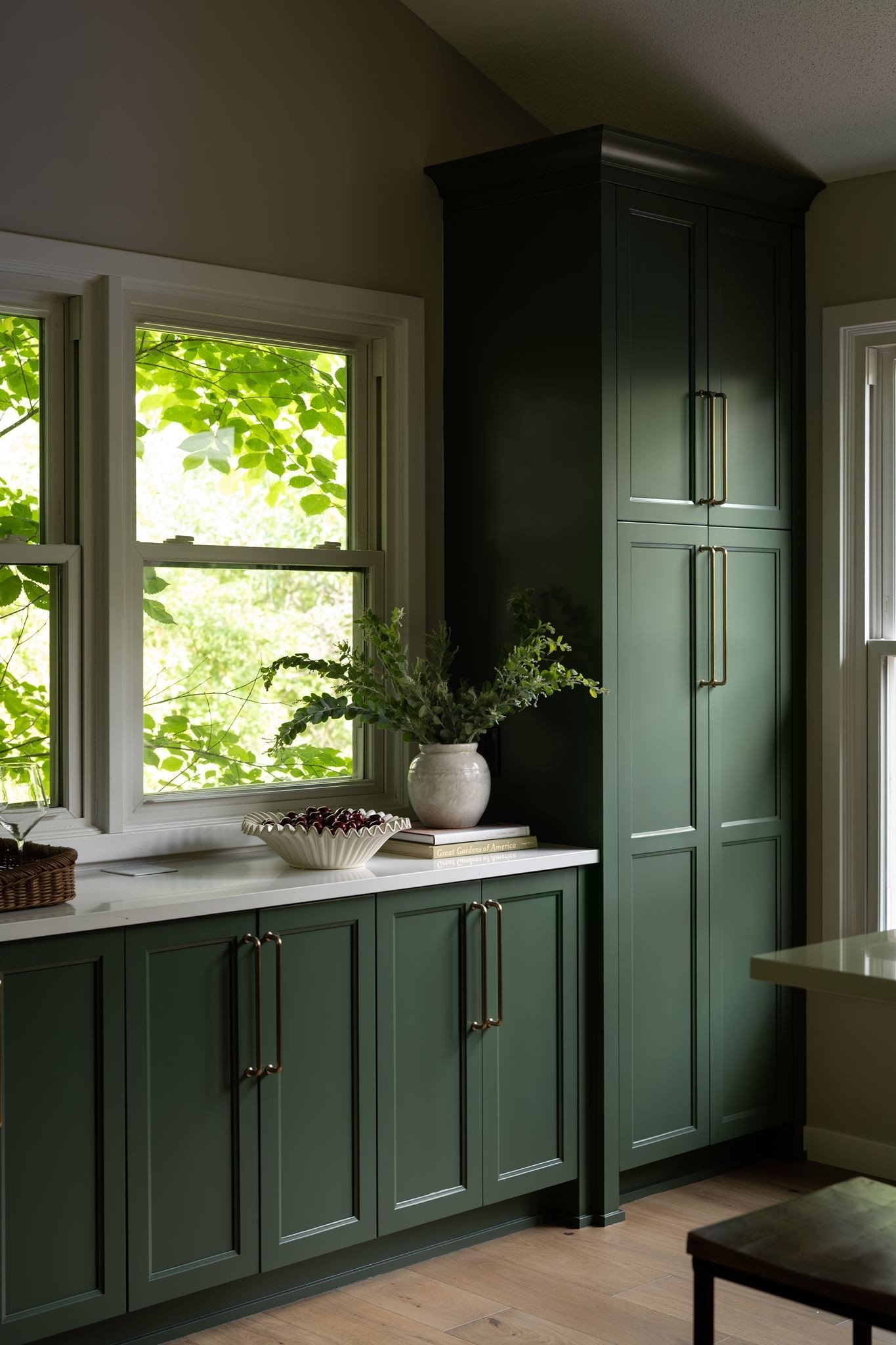 Ceramic bowl and stoneware vase styled on
quartz counter, dark green kitchen Eden
Prairie