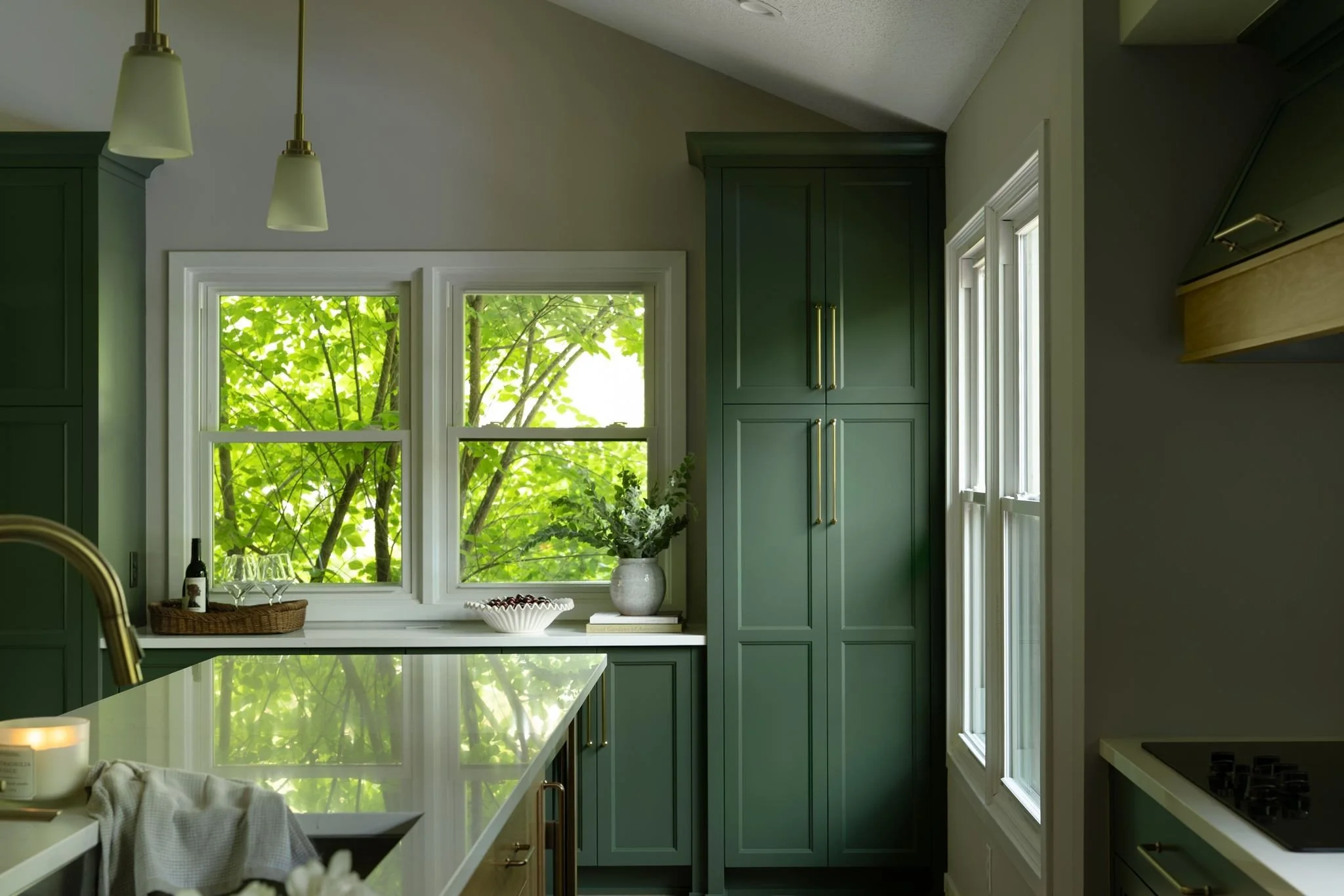 Dark green floor-to-ceiling kitchen cabinetry
with brass hardware, Eden Prairie