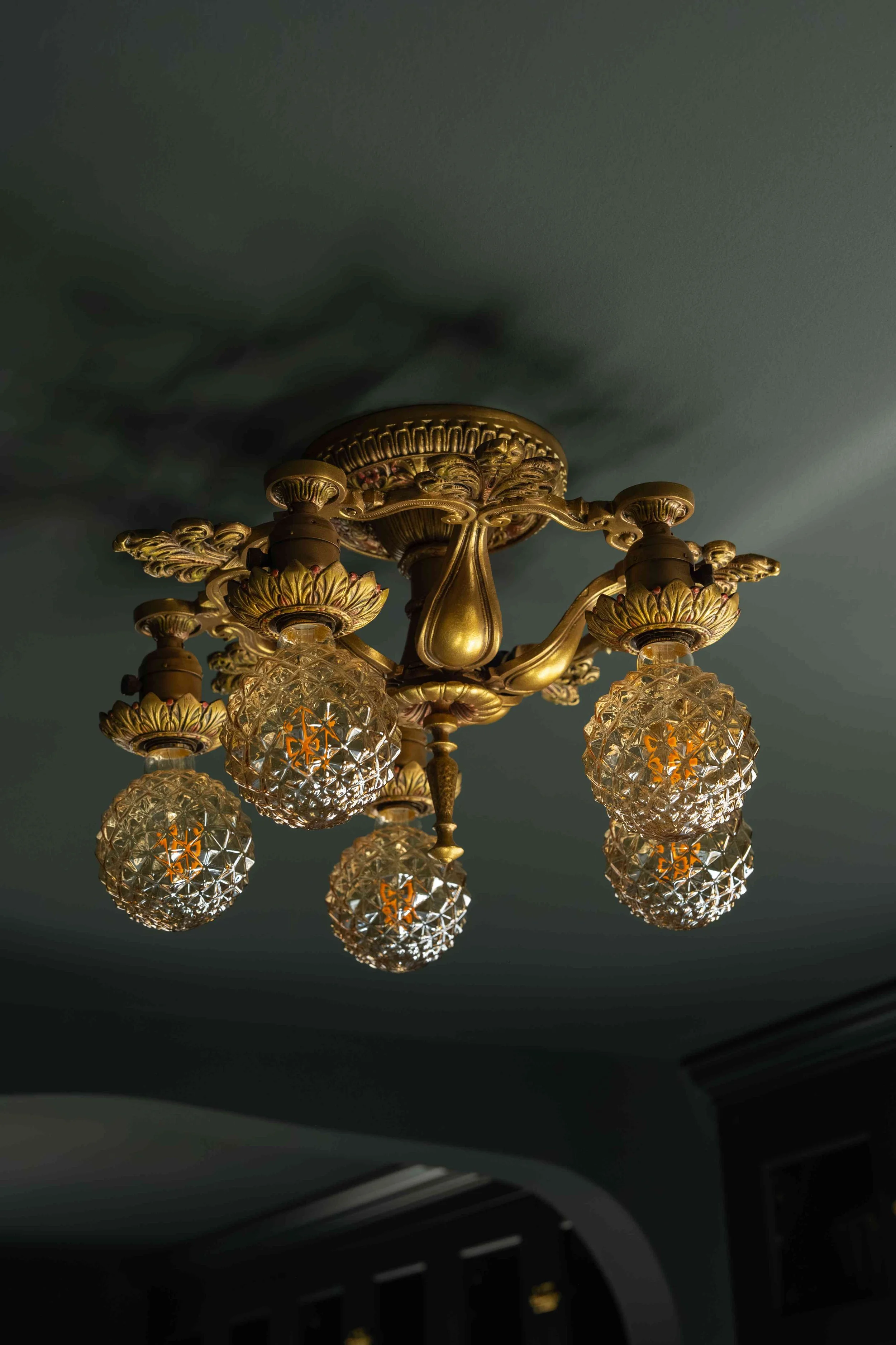 Restored antique brass chandelier with
crystal globes, dark kitchen ceiling,
Minneapolis