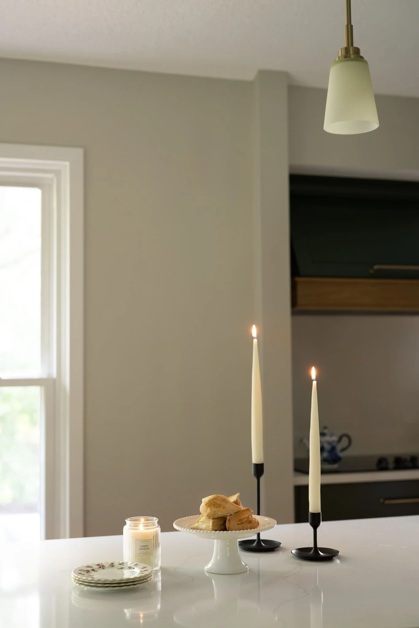 Taper candles and pastry display on quartz
island counter, Eden Prairie kitchen