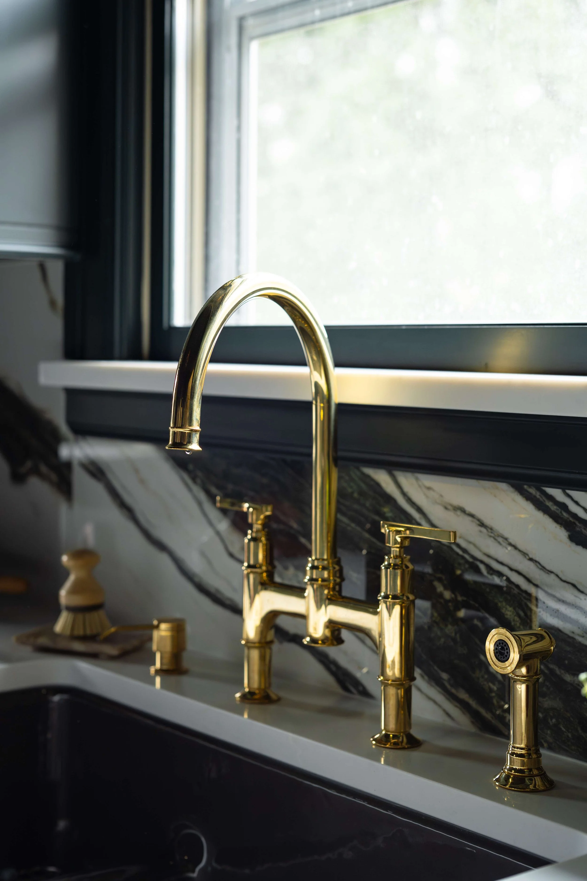 Unlacquered brass bridge faucet against
ceramic tile backsplash, custom kitchen
Minneapolis