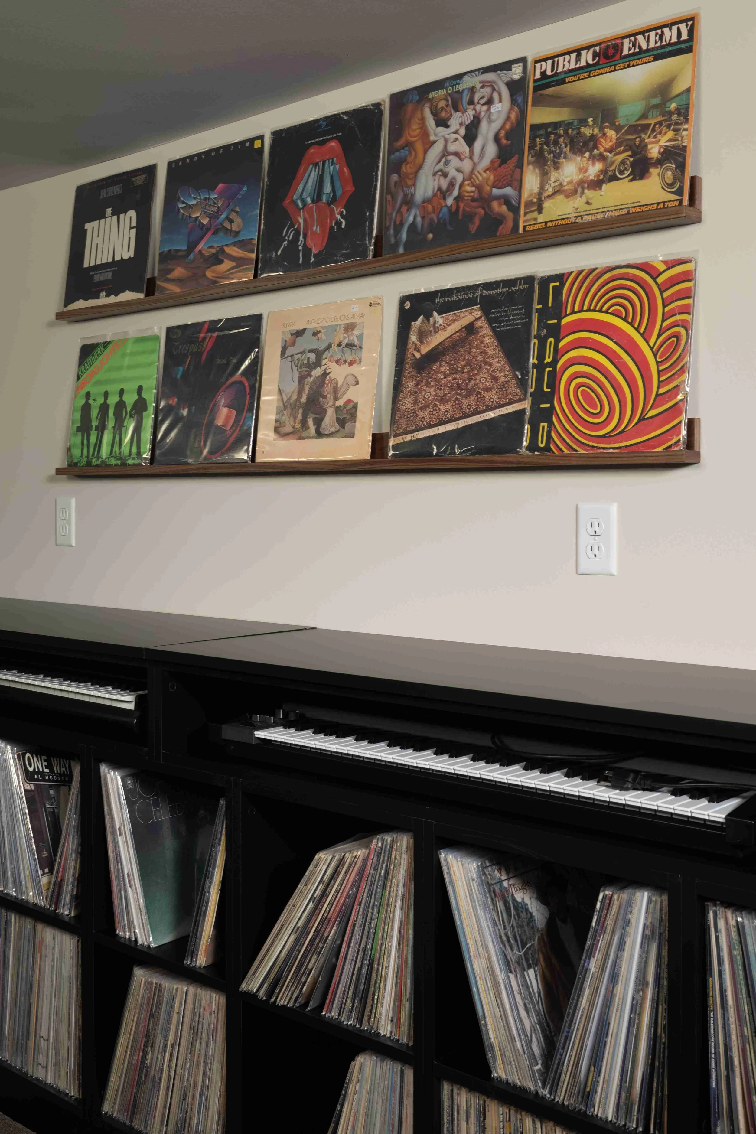 Colorful album art display above black built-in cabinetry, Minneapolis basement remodel