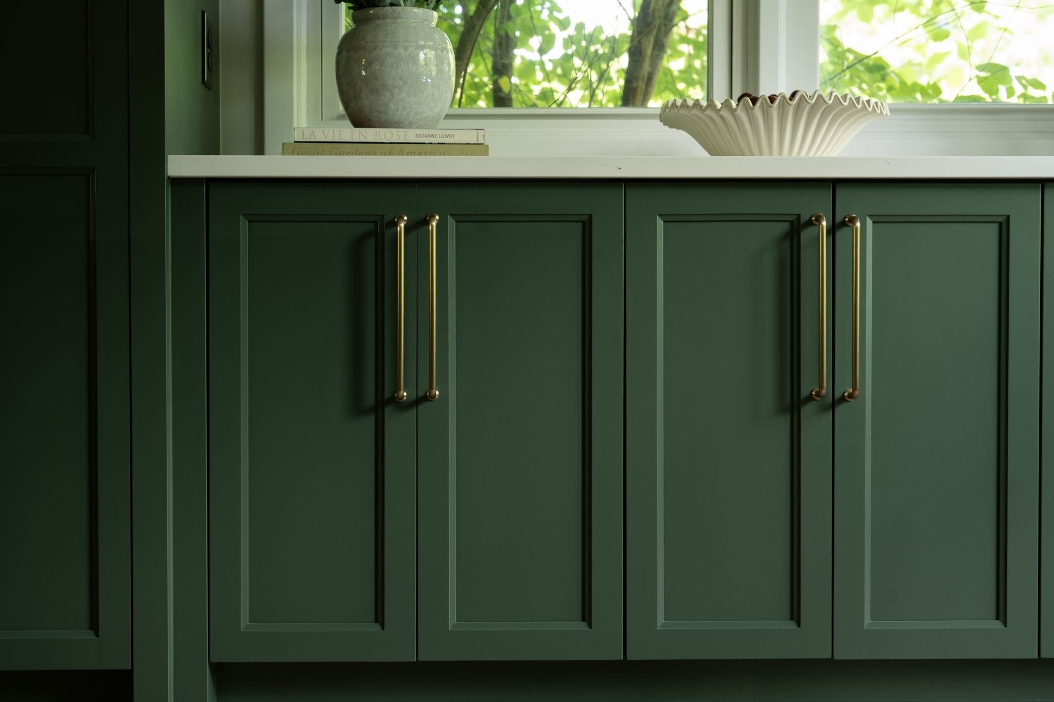Brass bar pull hardware detail on dark green
shaker cabinetry, Eden Prairie kitchen