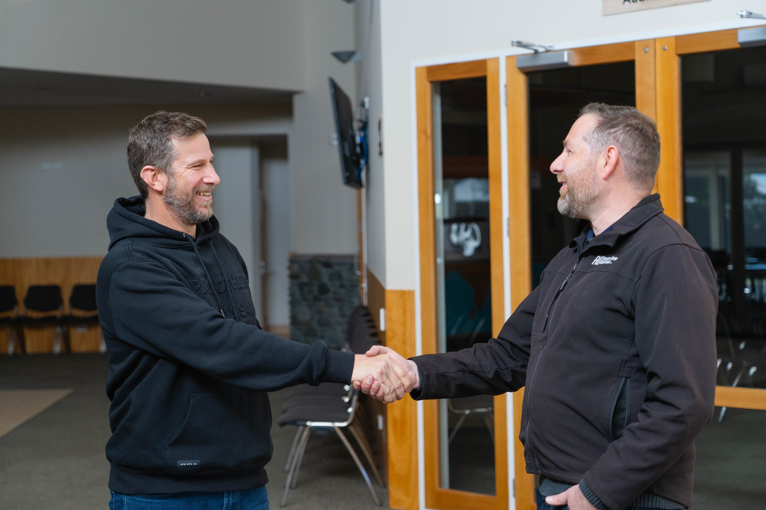 Rowan Dron shaking hands with a happy client.