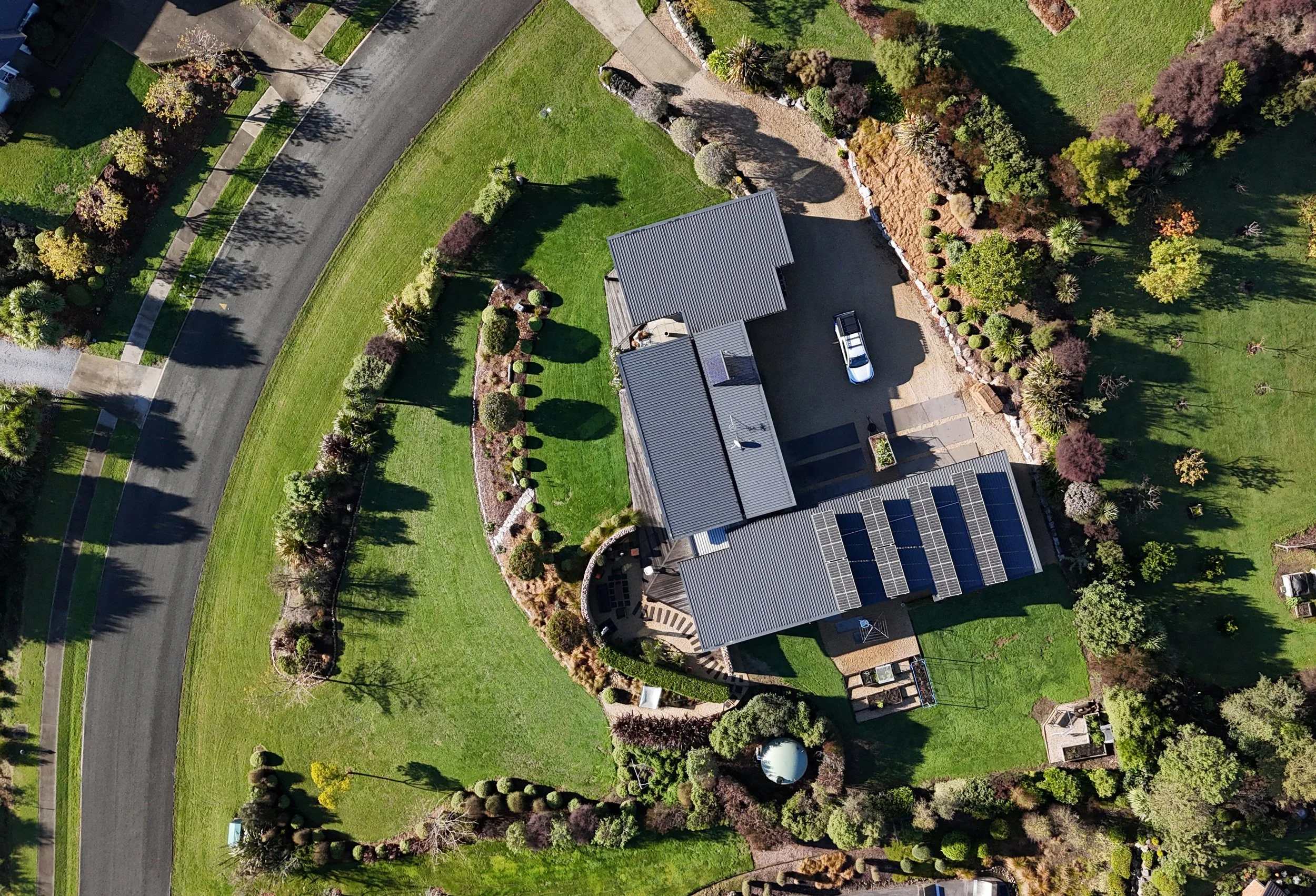 An aerial view of a residential property featuring a house with solar panels