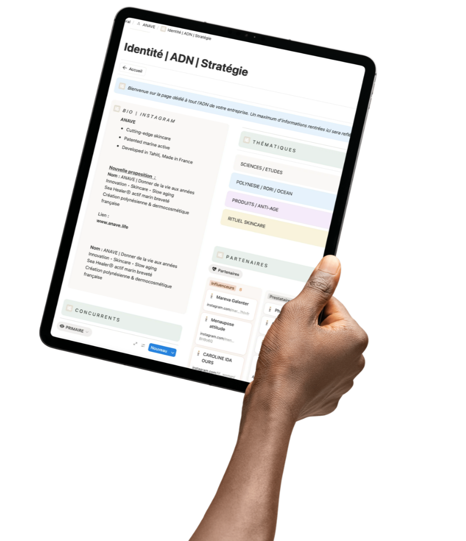 Une main tient une tablette affichant une page web en français sur la stratégie d'identité ADN, avec des sections pour BIO, THÉMATIQUES, PARTENAIRES, CONCURRENTS et autres.