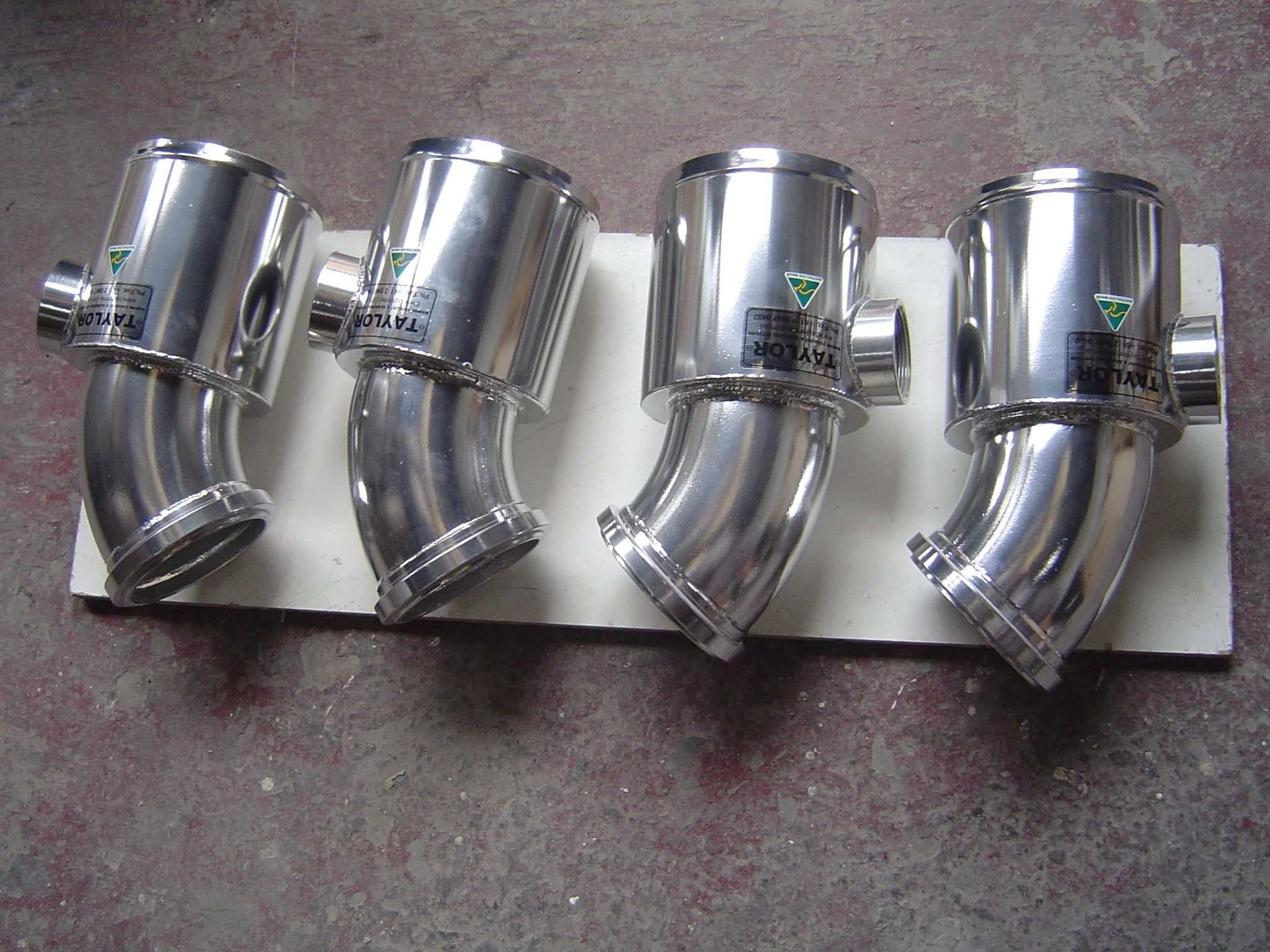 Marine-grade stainless steel exhaust risers fabricated for vessel installations.