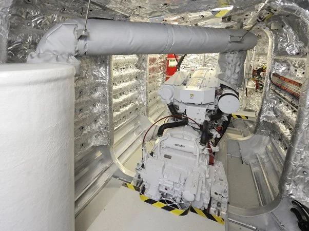 Custom insulated marine exhaust installation engineered for high-temperature engine room applications.