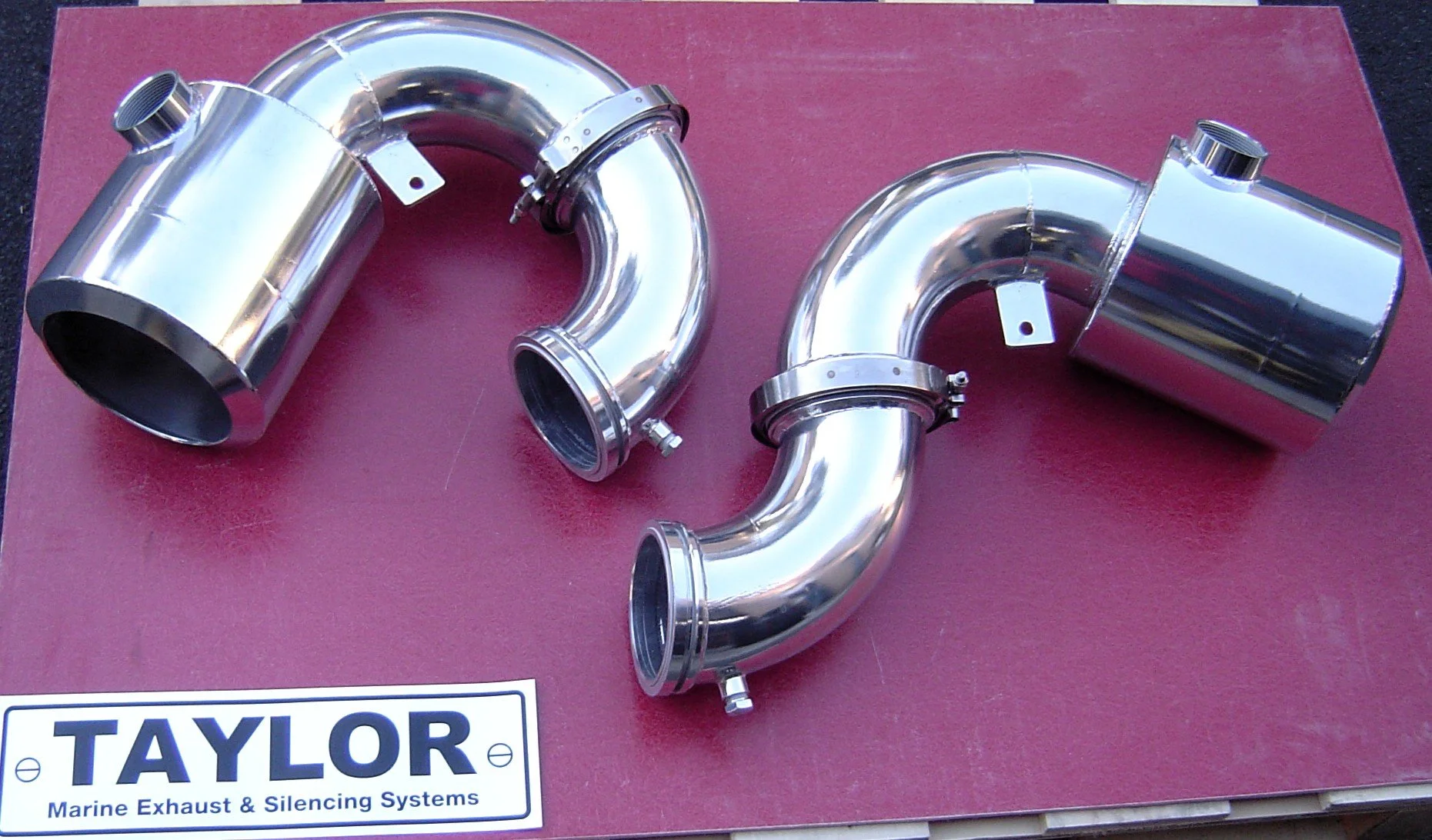 Polished stainless steel marine exhaust elbows manufactured by Taylor Marine Exhaust.