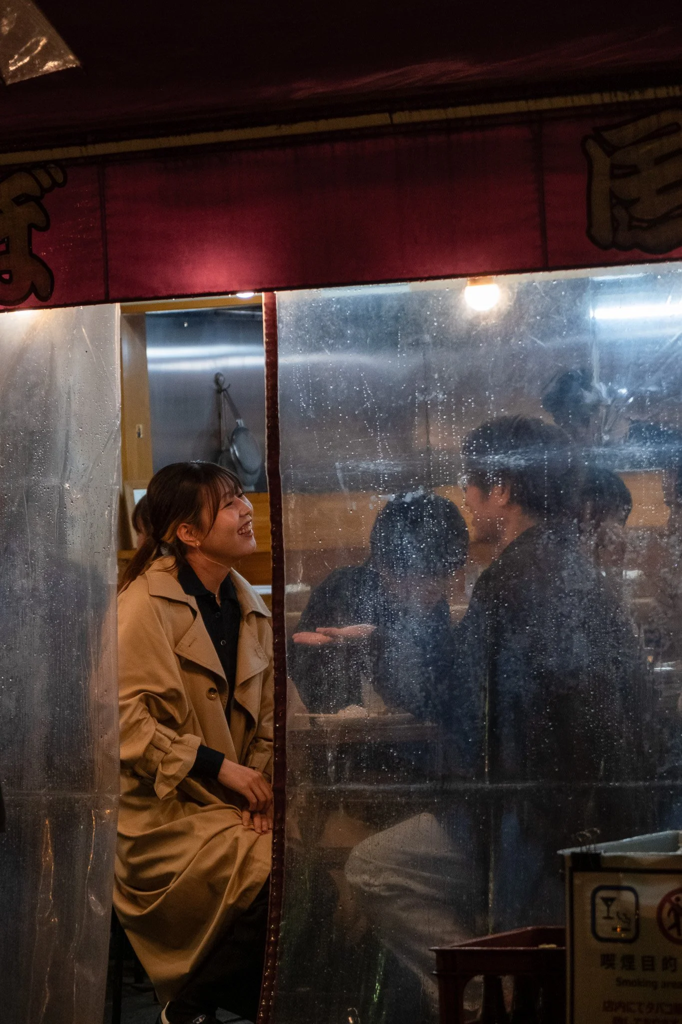 Couple sitting inside a small Tokyo restaurant during a rainy night in Japan.
