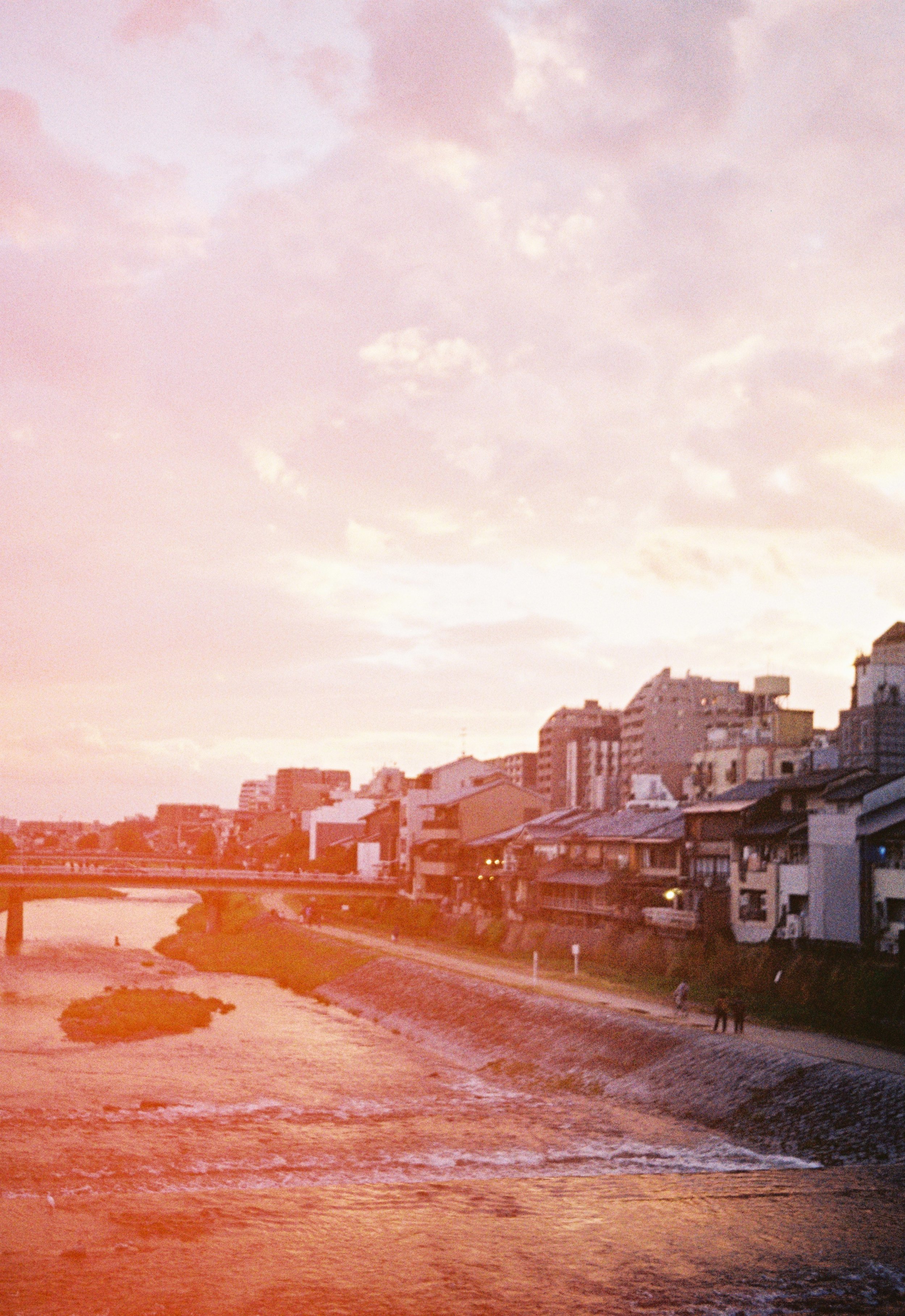 Sunset over the river in Kyoto with warm light leaks on Kodak Gold 200 film.