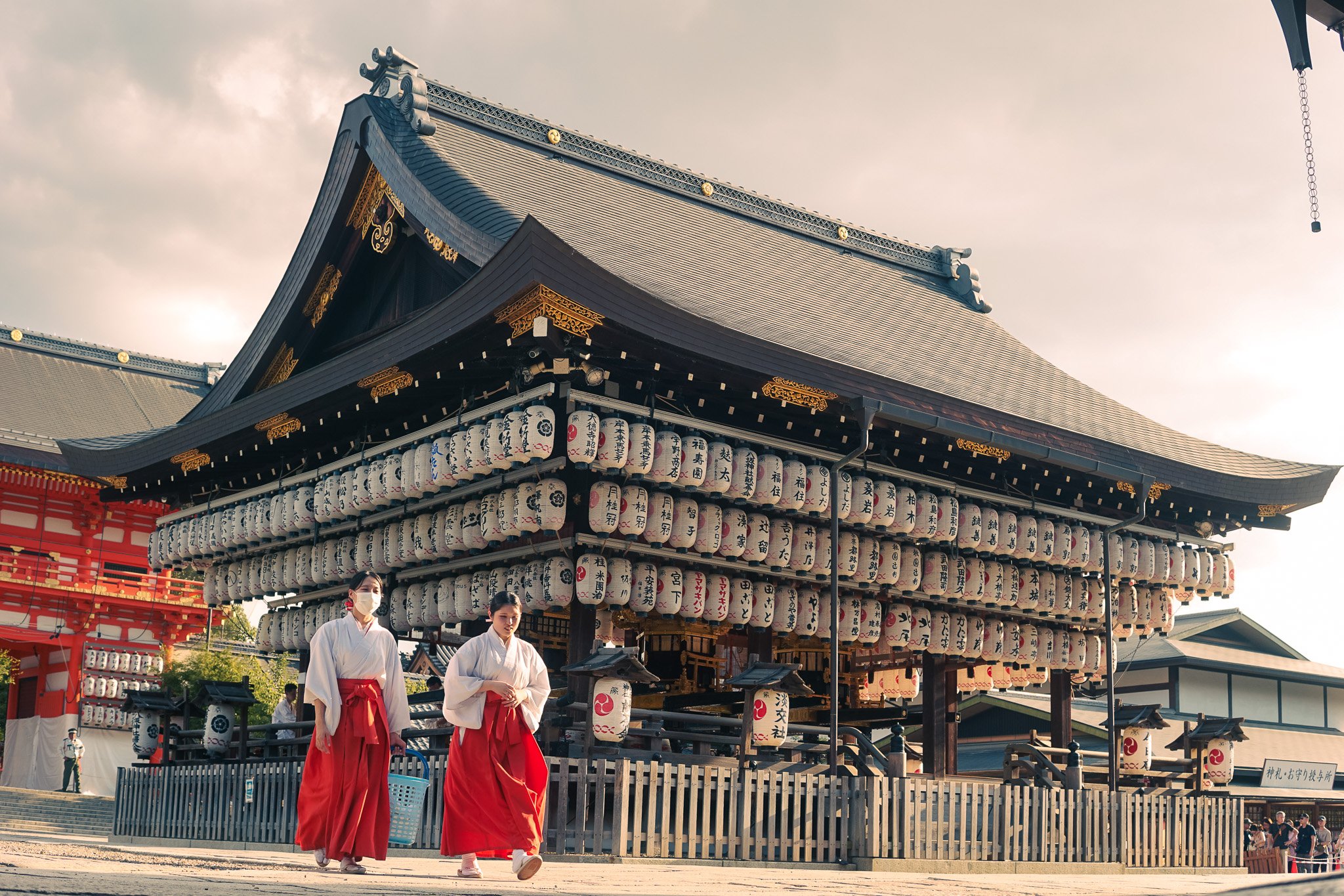 Women in traditional clothing walking near Yasaka Shrine during Gion Matsuri in Kyoto.