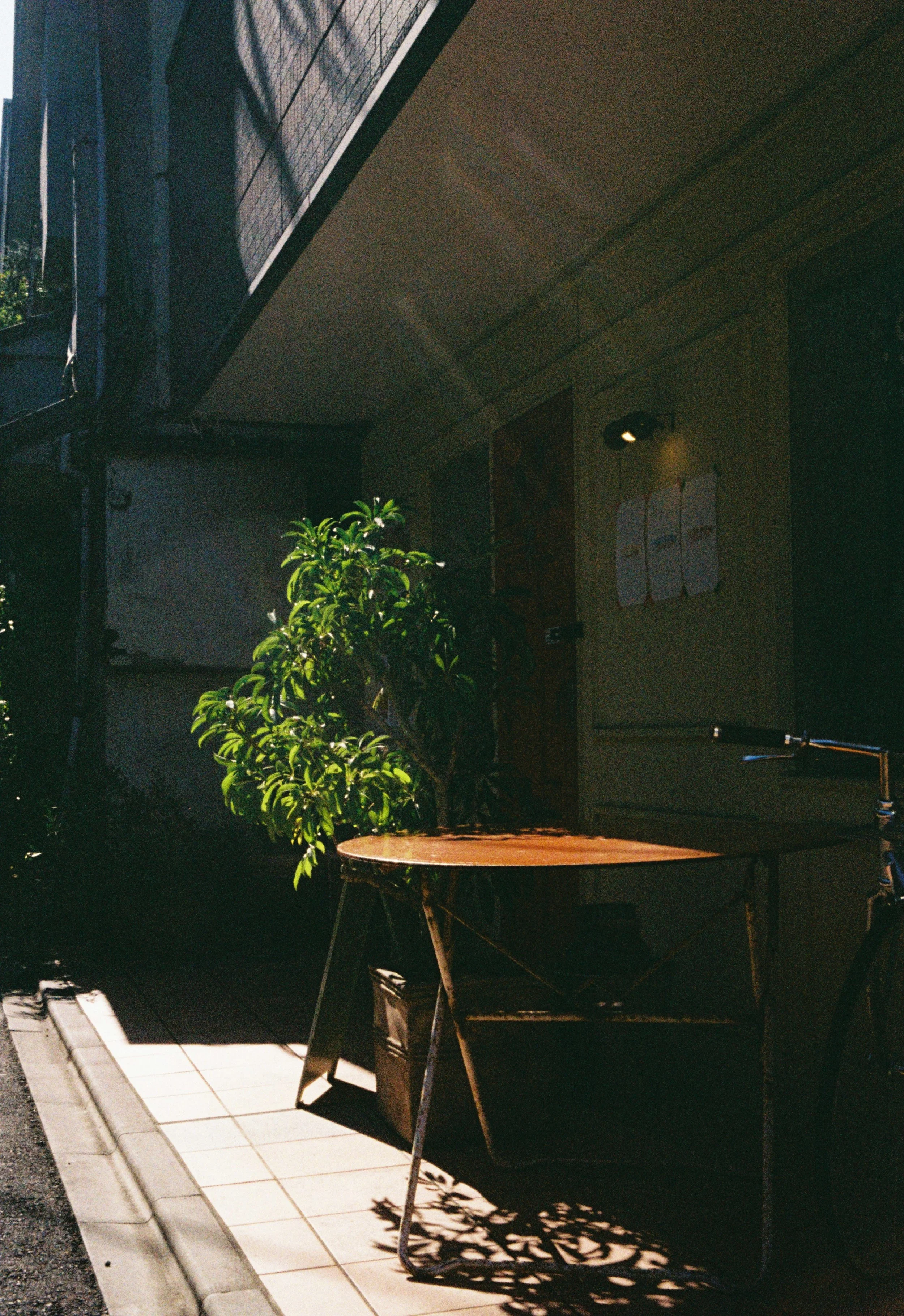 Minimal Japanese street corner with table and sunlight captured on Kodak Gold 200.