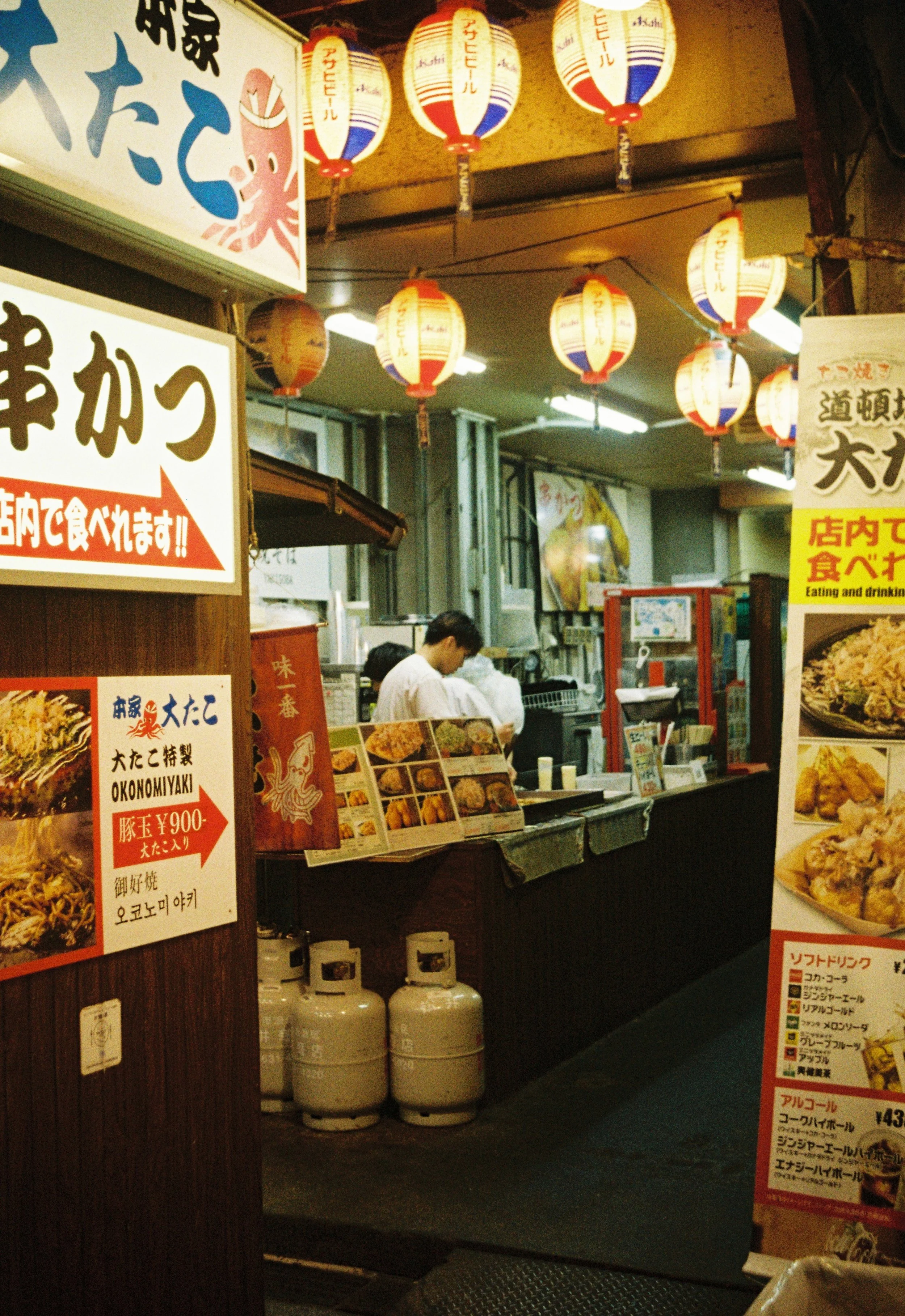 Night food alley in Osaka illuminated by lanterns and photographed on film.