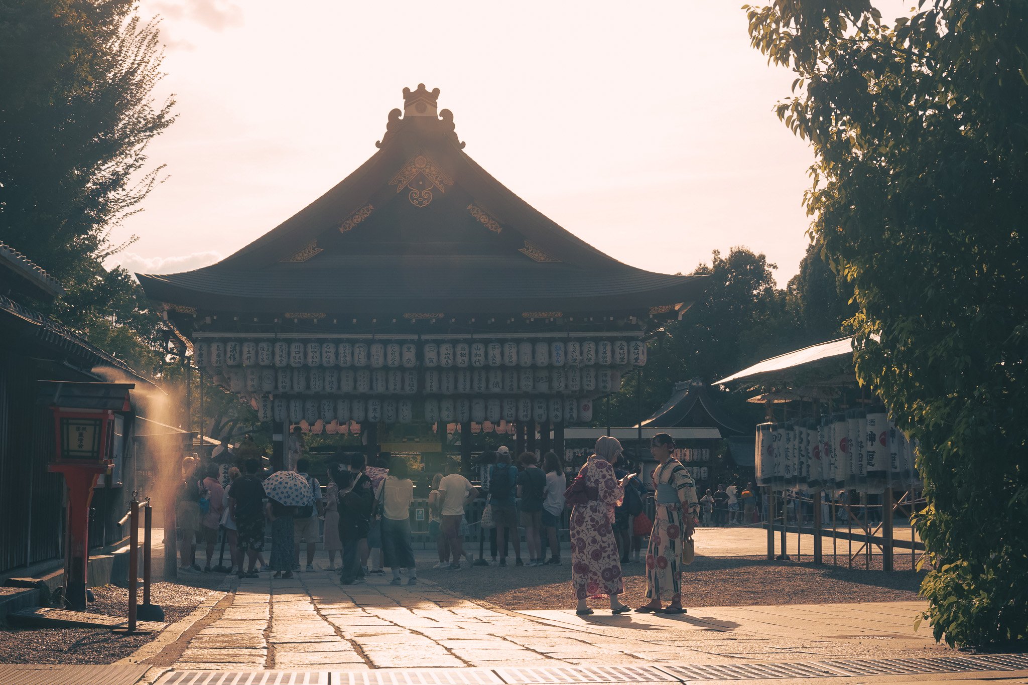 People gathering at Yasaka Shrine during golden hour in Kyoto, Japan.