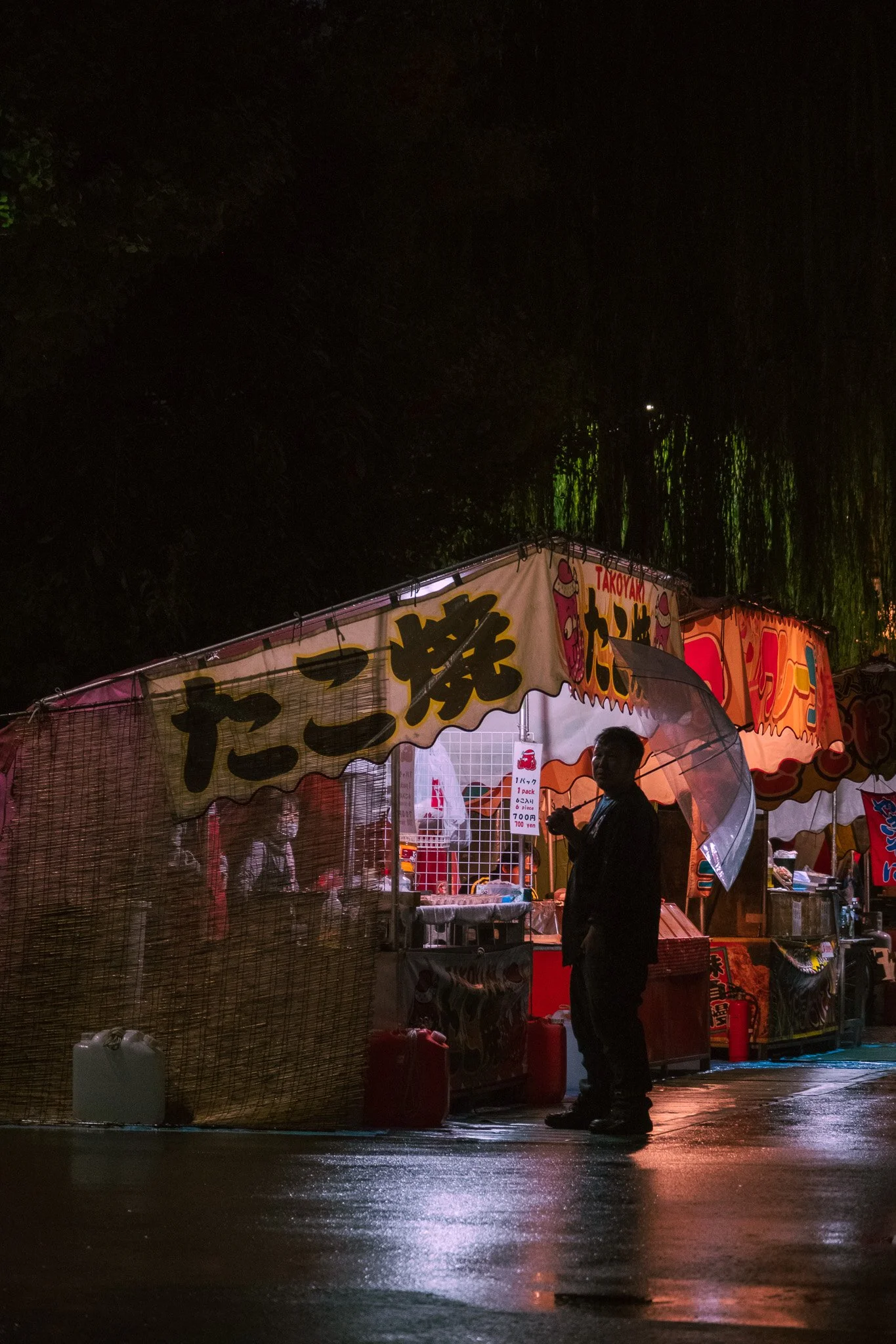 Street food stand glowing during a rainy evening in Tokyo, Japan.