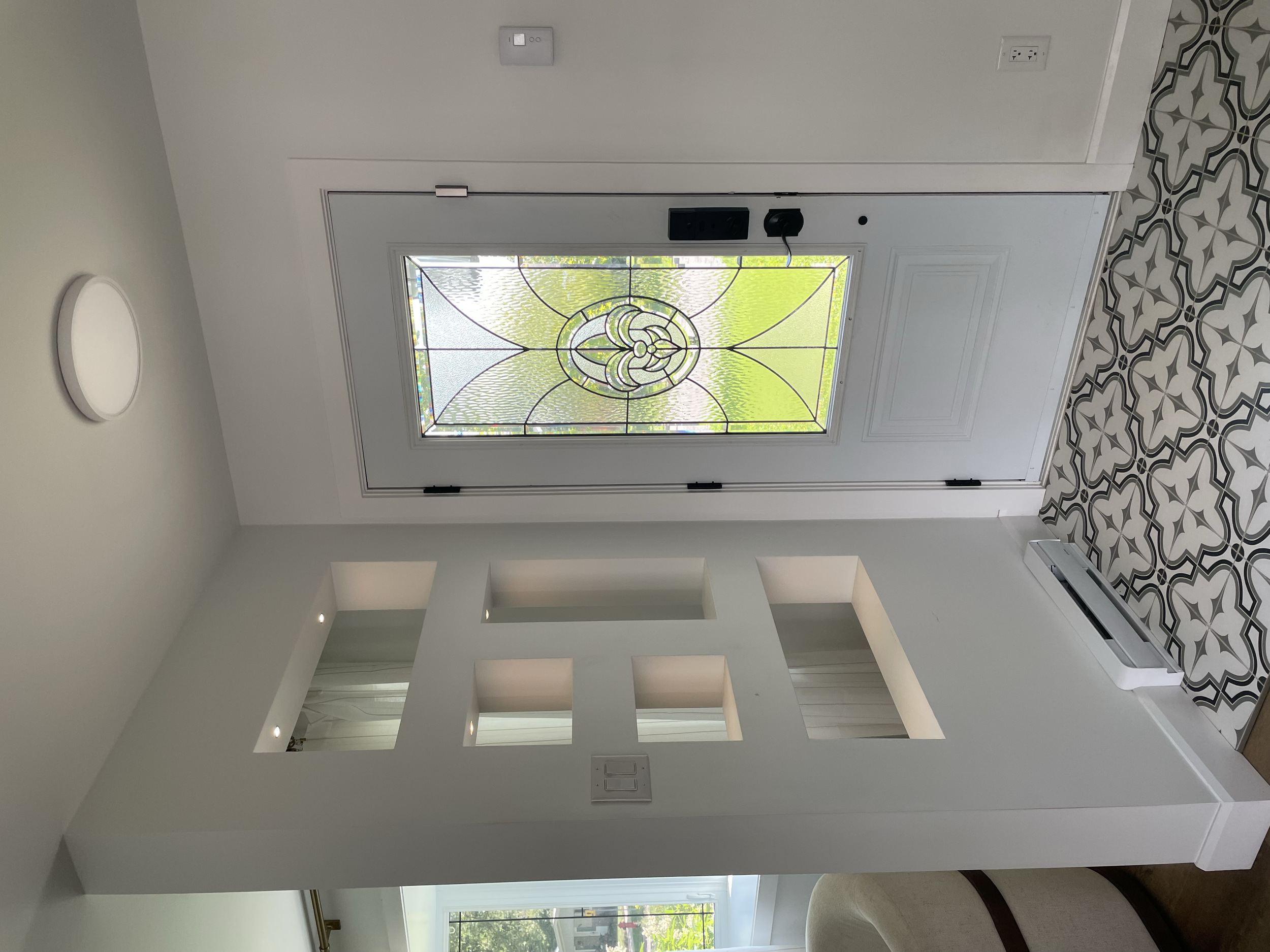 Custom interior project by Garcia Construction Rénovation in Quebec City featuring a custom-built divider wall with geometric openings separating the entryway from the living room.