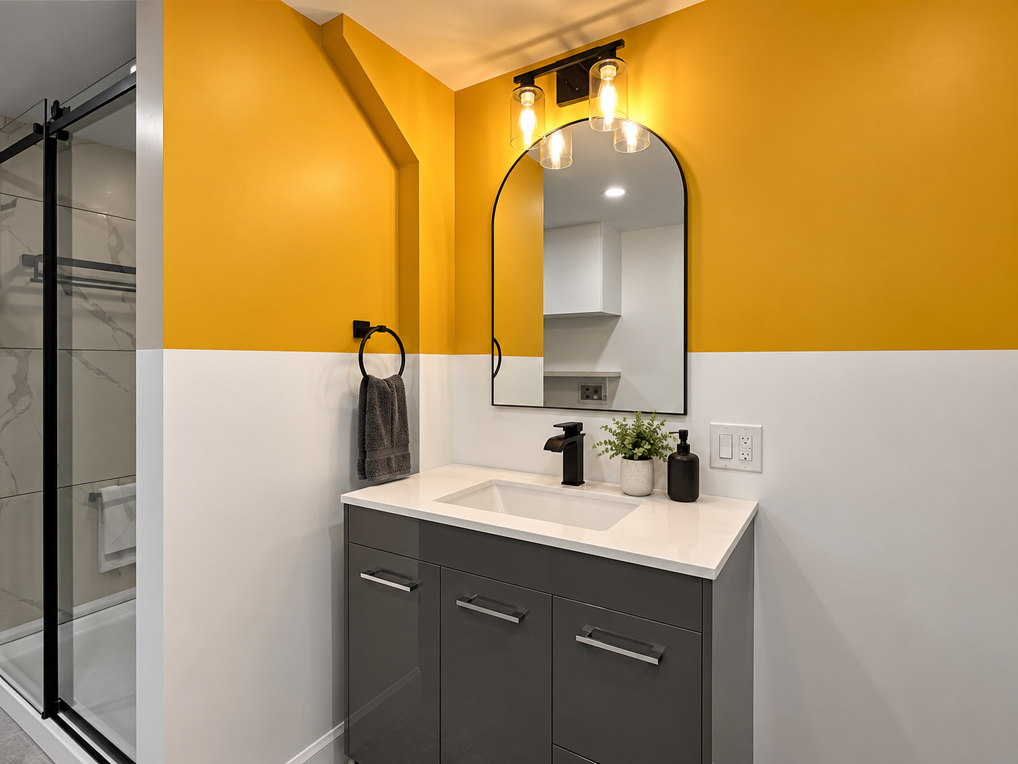 Petite salle de bain de sous-sol rénovée par Garcia Construction Rénovation à Québec, avec vanité simple grise, comptoir blanc et mur d’accent jaune.
