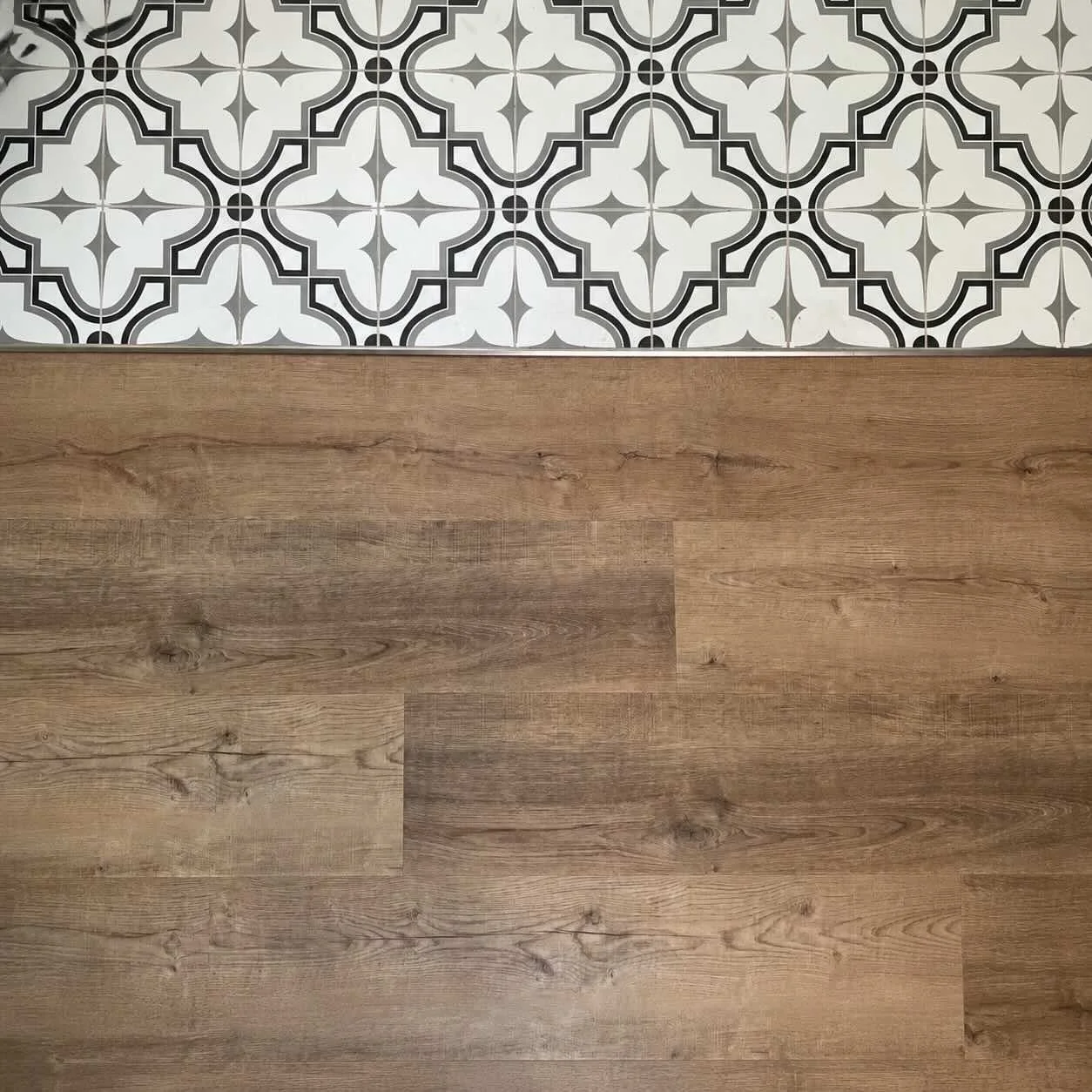 Couvre-plancher installé par Garcia Construction Rénovation à Québec, avec plancher effet bois et tuiles décoratives.