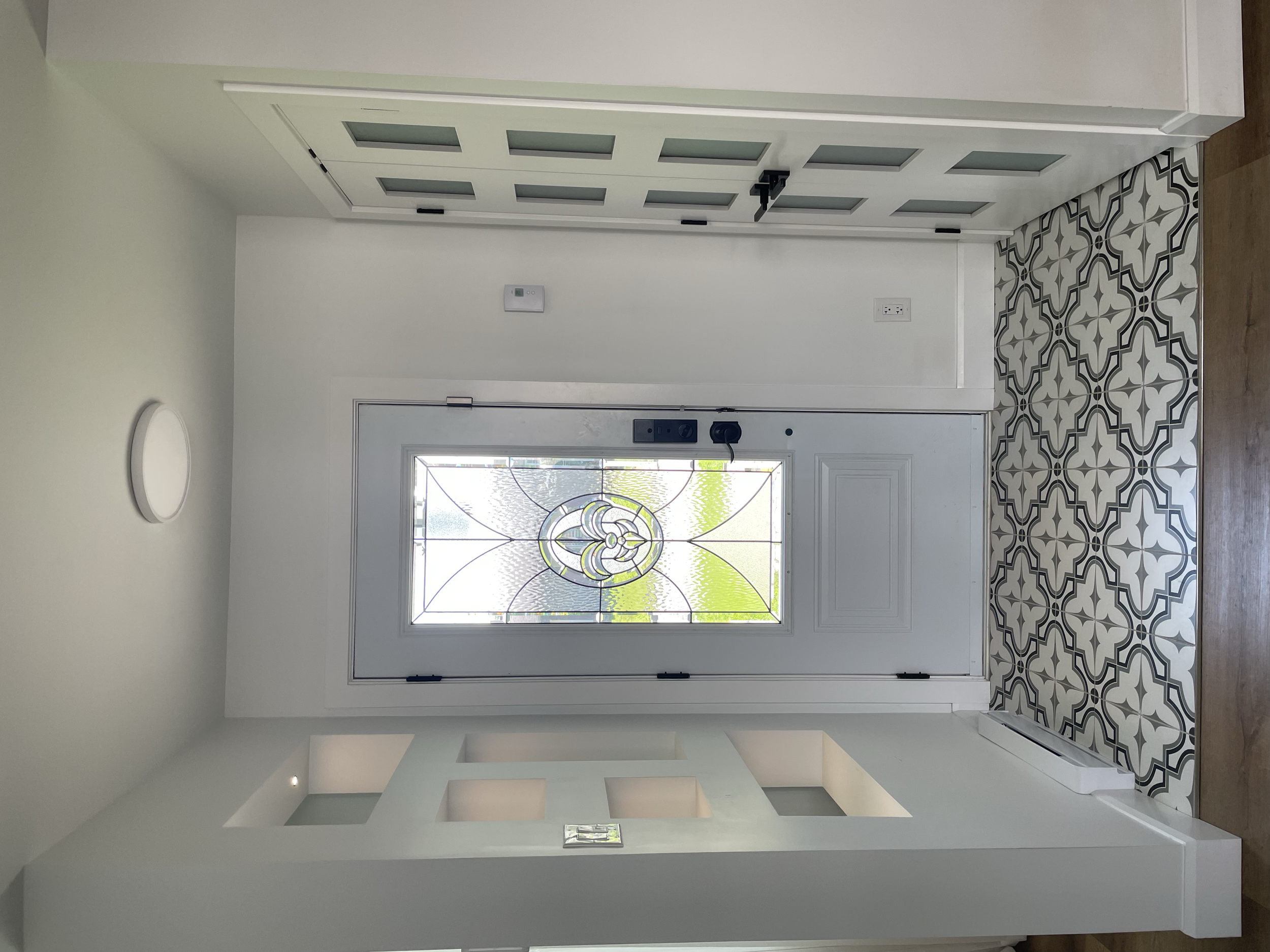 Custom-built divider wall by Garcia Construction Rénovation in Quebec City featuring geometric openings and an integrated entryway closet, creating separation while maintaining an open and bright interior.