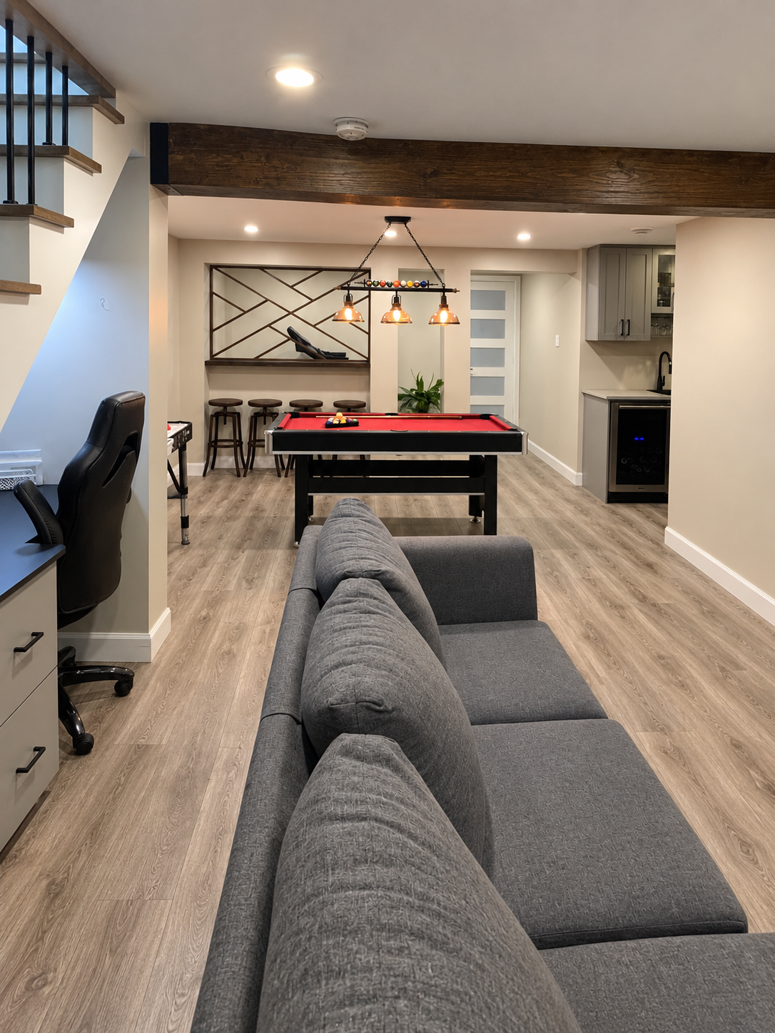 Rénovation de sous-sol réalisée par Garcia Construction Rénovation à Québec, avec salle familiale, espace de divertissement, éclairage encastré et plancher effet bois.
