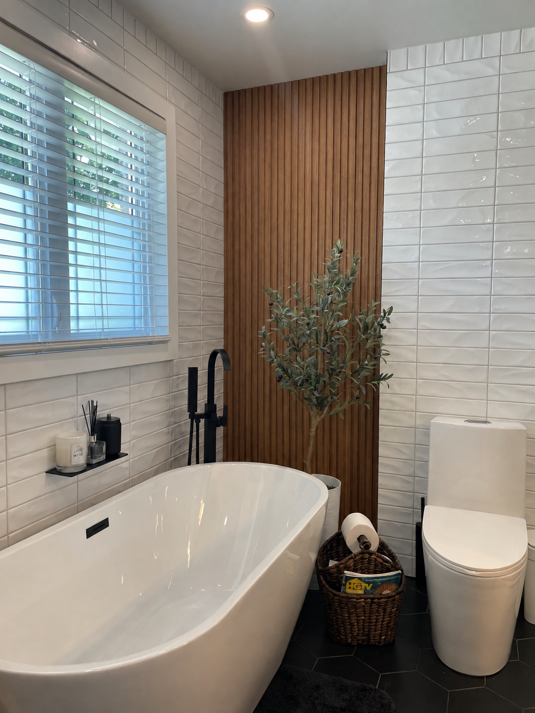 Rénovation de salle de bain réalisée par Garcia Construction Rénovation à Québec, avec baignoire autoportante, mur d’accent en bois, robinetterie noire et fenêtre au-dessus de la baignoire.