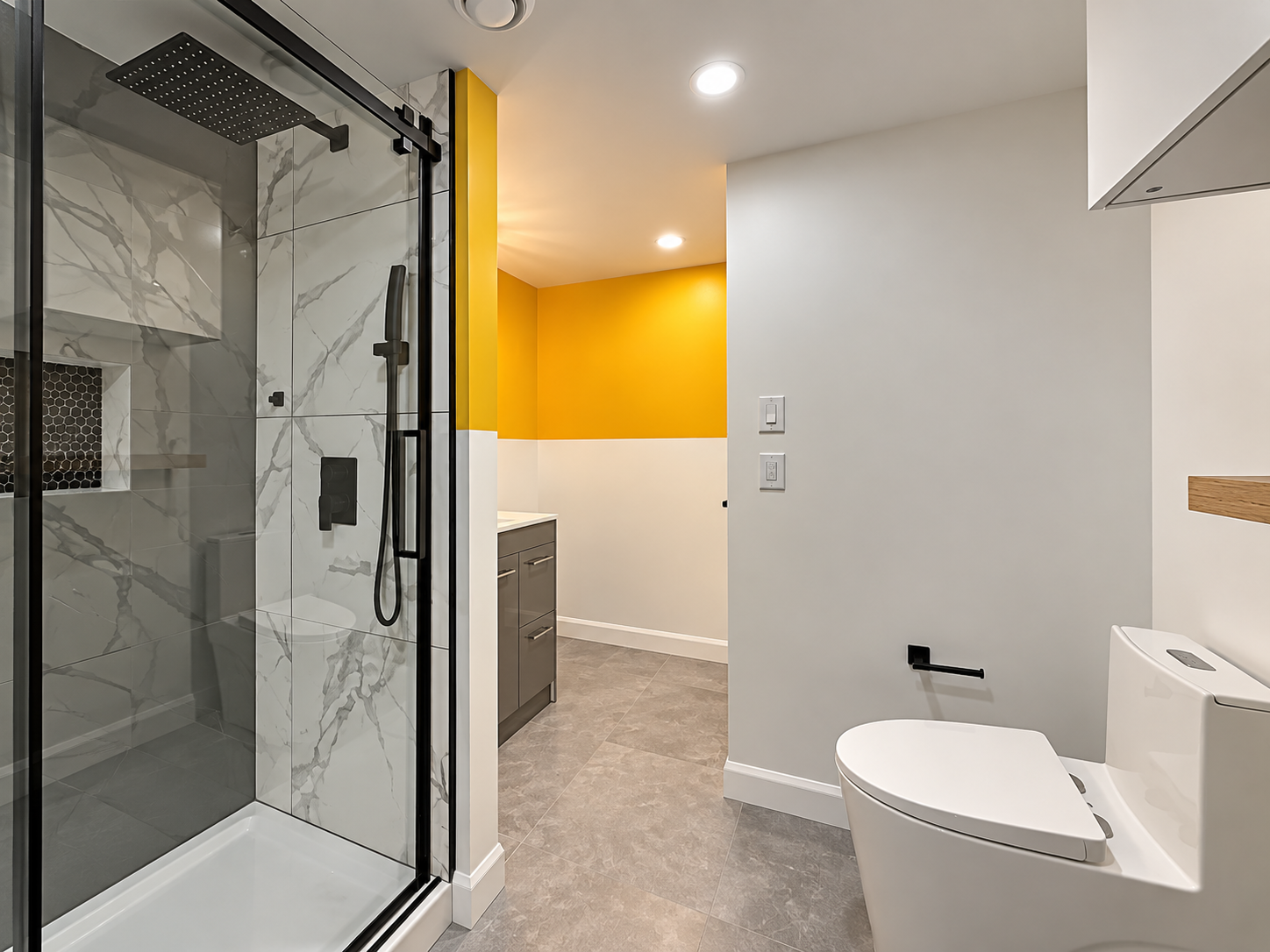 Petite salle de bain de sous-sol rénovée par Garcia Construction Rénovation à Québec, avec douche vitrée et mur d’accent jaune.