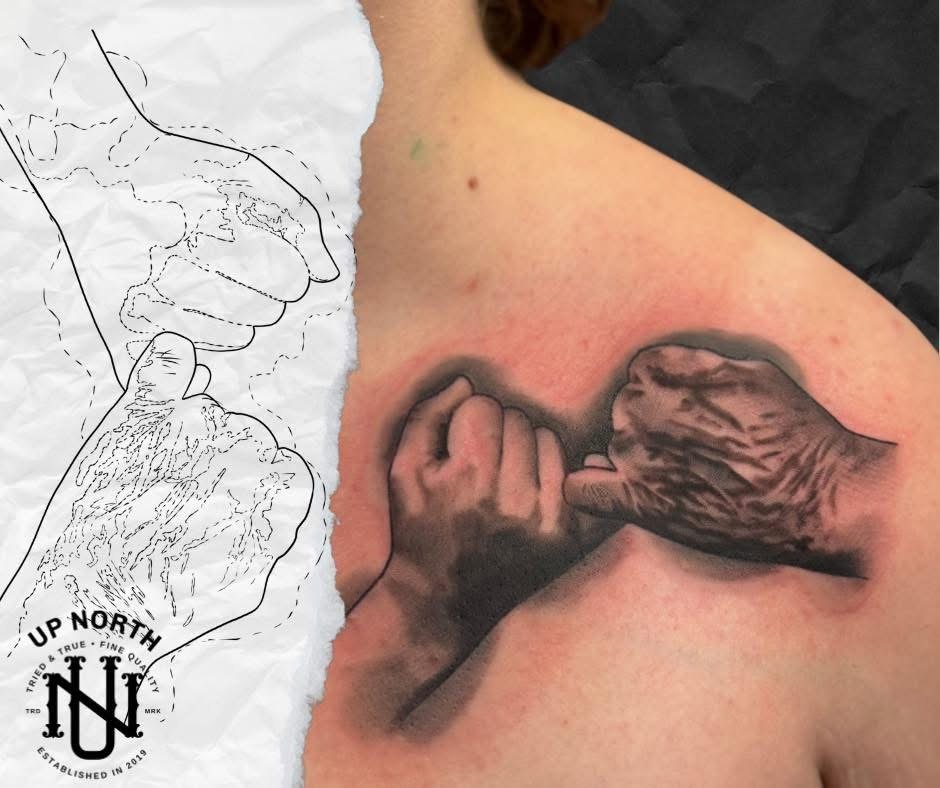 Tattoo of a hand gripping a branch on a person's shoulder, with a sketch of the same hand and branch appearing beside it.