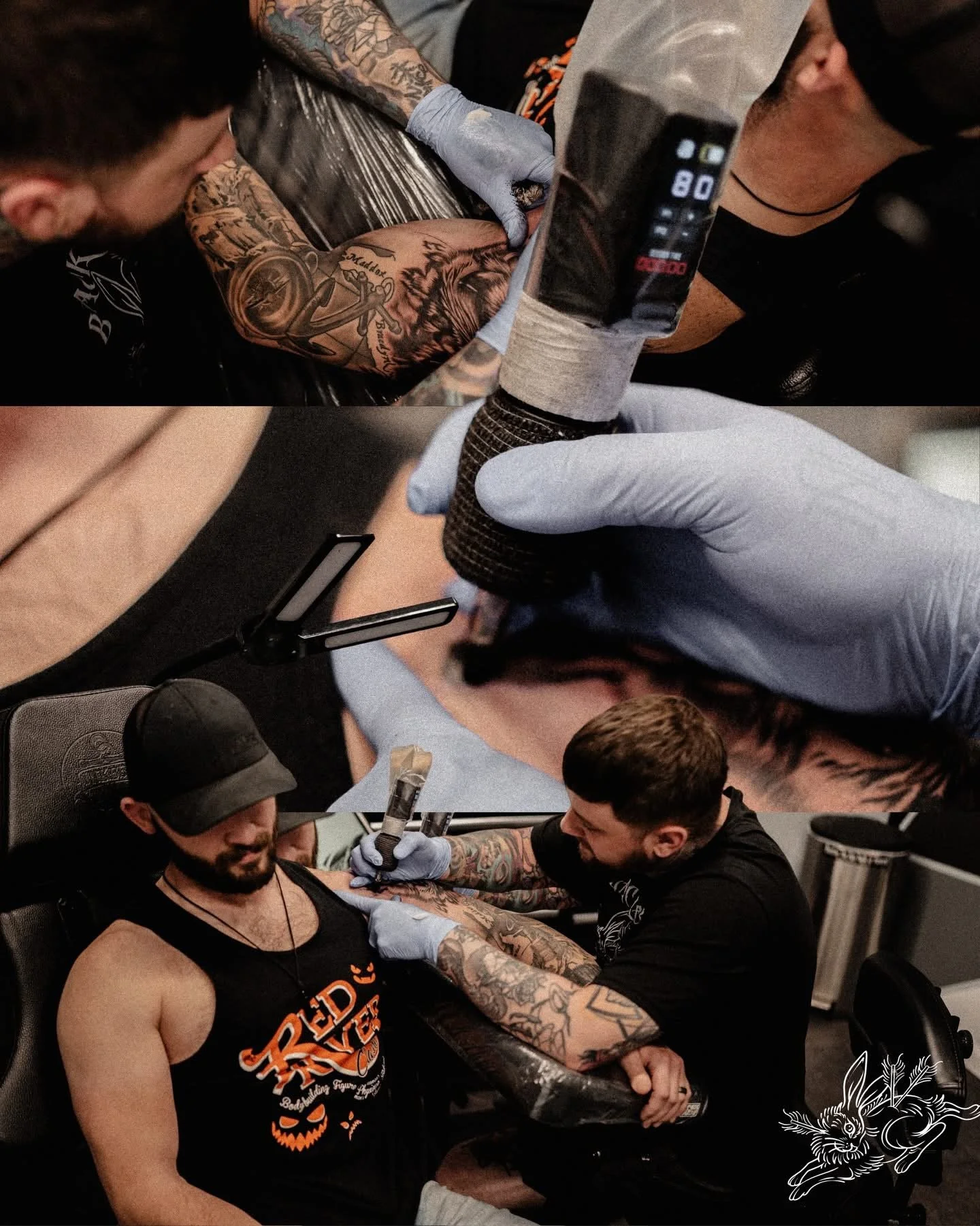 A man with tattoos on his arm receiving a tattoo on his upper arm from a tattoo artist in a tattoo studio.