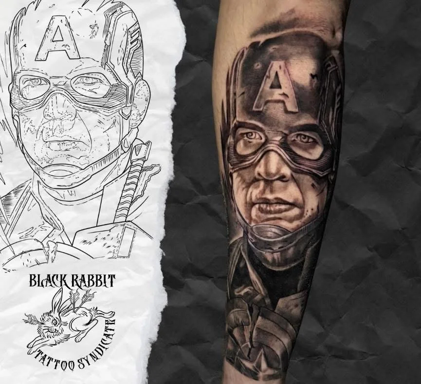 A realistic black and gray tattoo of a person's face wearing glasses and a helmet with the letter A on it, on a person's arm.