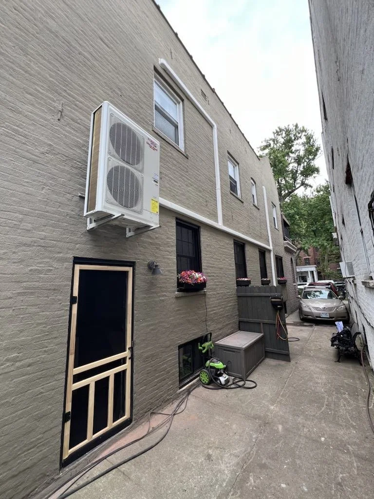 Rear of a Park Slope brick building with the outdoor mini-split unit mounted on the wall