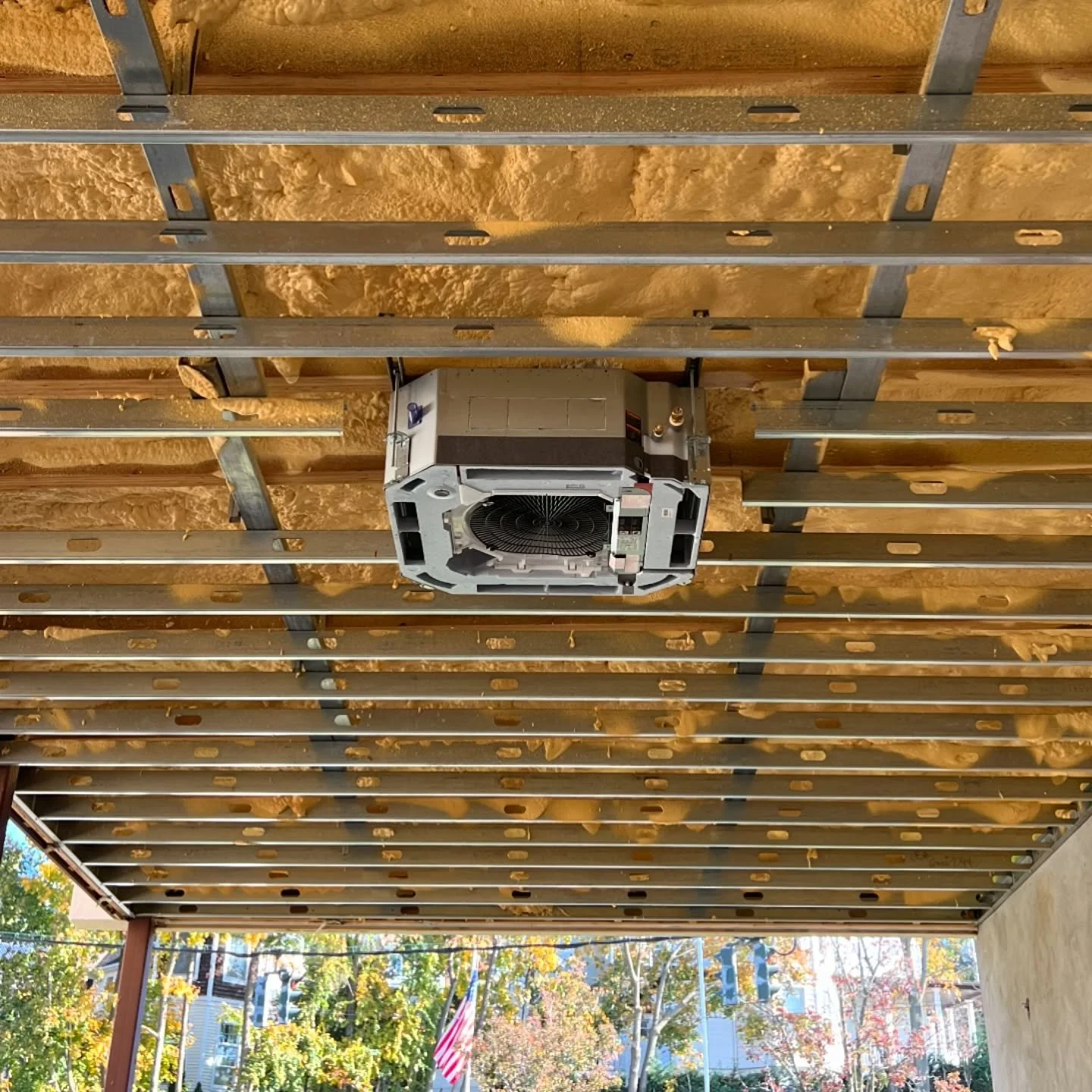 Ceiling with metal framing and insulation, HVAC unit in the center, partially built ceiling.
