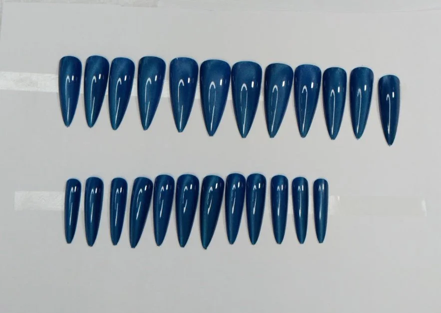 Two rows of blue, elongated, pointed Custom press in nails