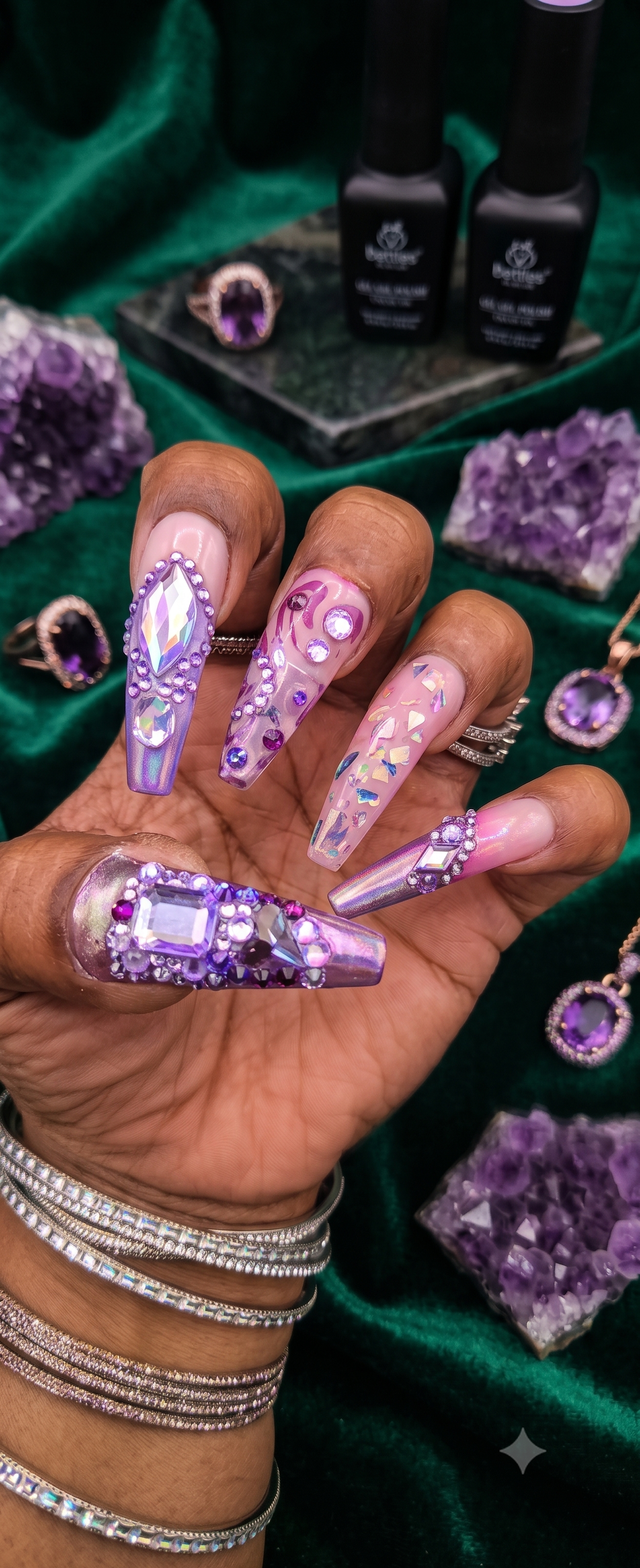 Purple nails with beautiful design and rhinestones on a rich background